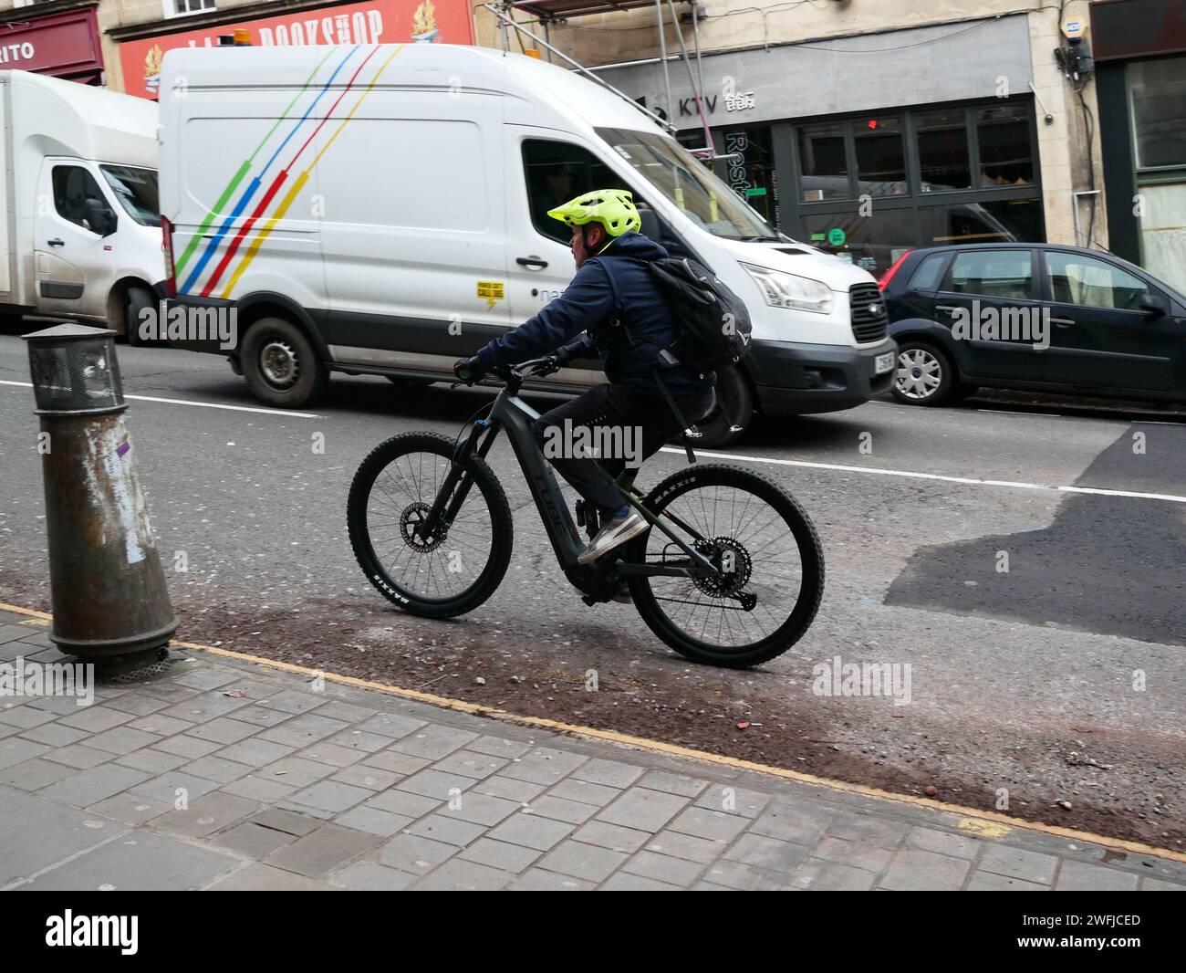 Man riding bicycle up Park Street, Bristol, UK Stock Photo