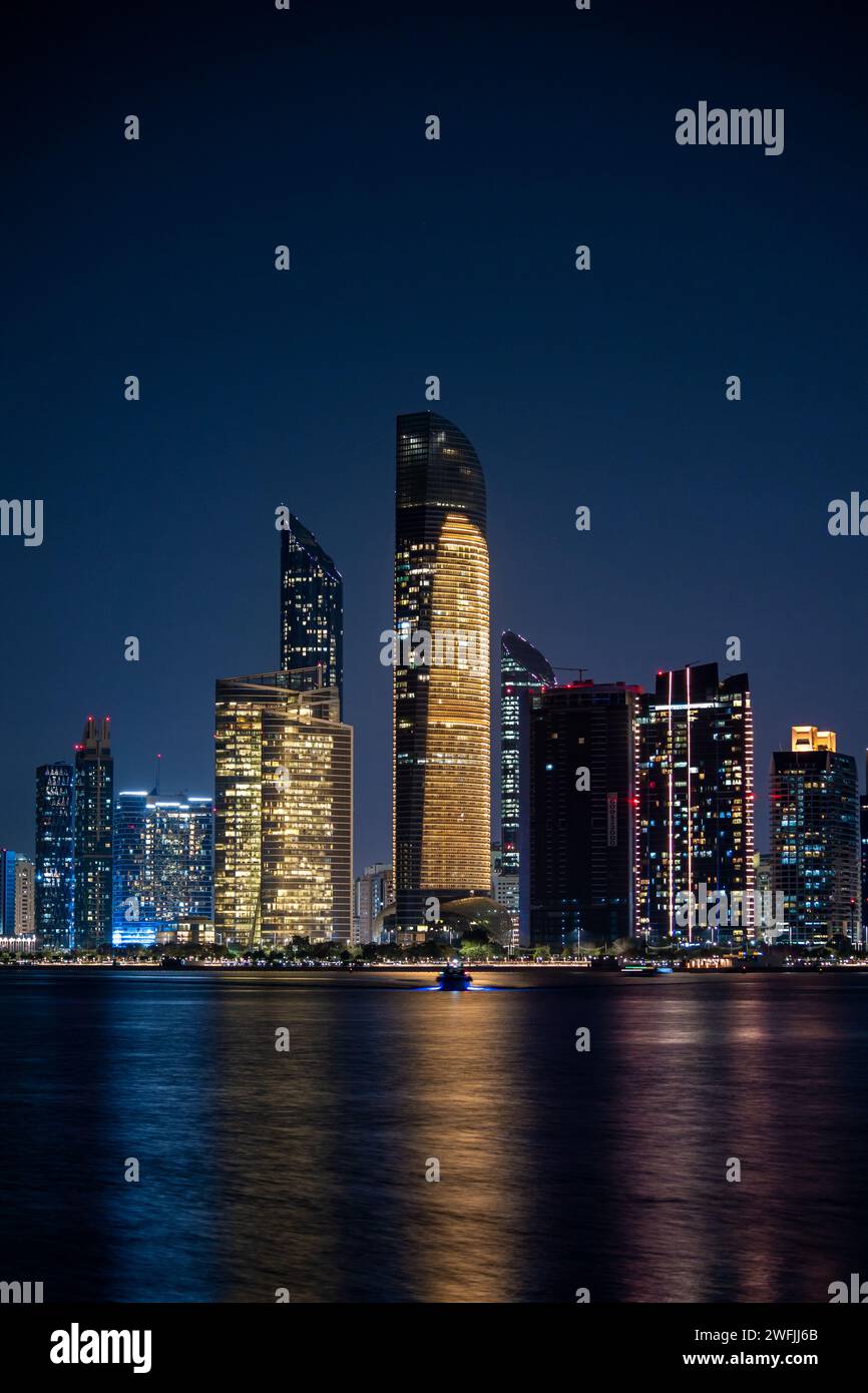 The Abu Dhabi skyline in the night with a boat driving away - Abu Dhabi ...