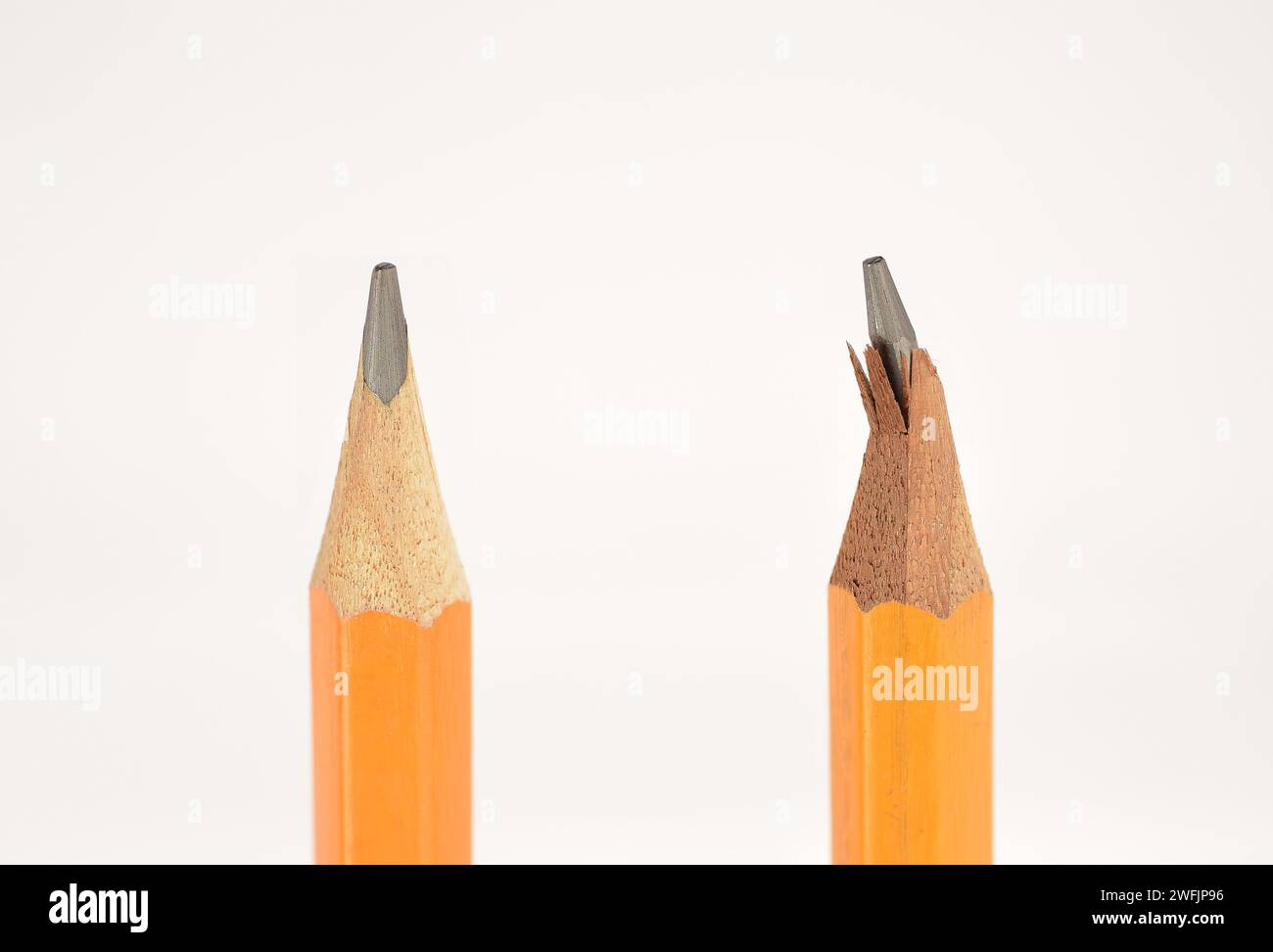 Two pencils, one is new and another is with broken tip or graphite. Isolated on white background. Close Up. Stock Photo