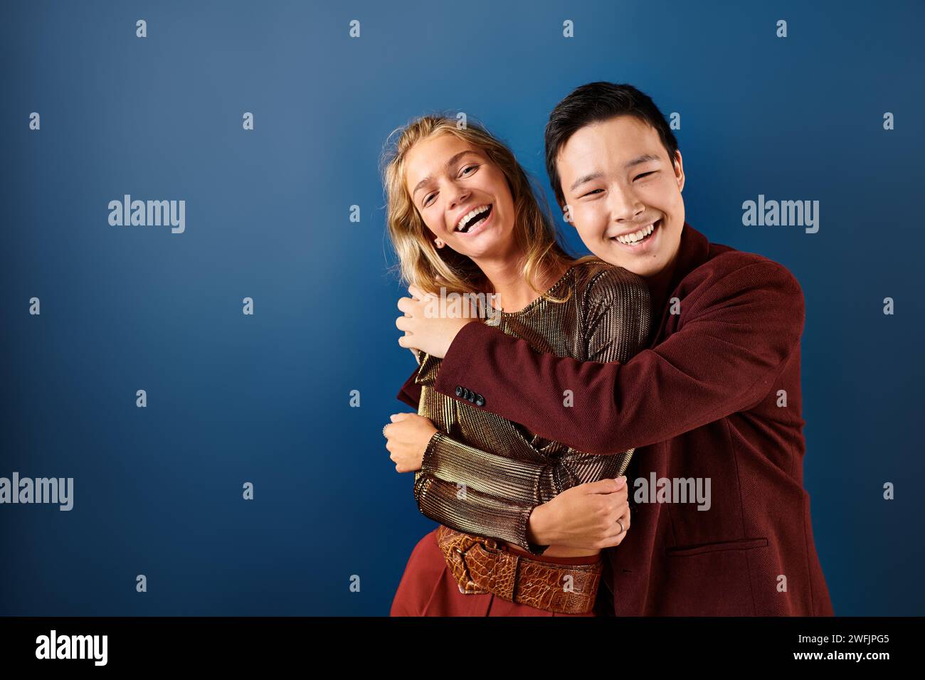 joyous multiracial teenage boy and girl hugging and smiling happily at ...