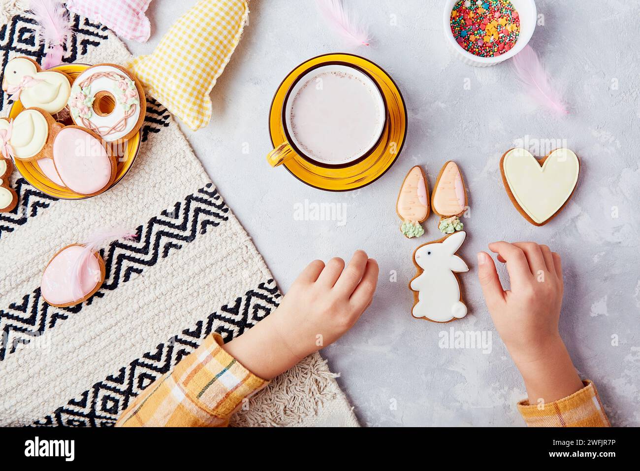 Cozy kids snack time. Tradition Easter cookies. Children delightful Easter happiness flat lay. Stock Photo