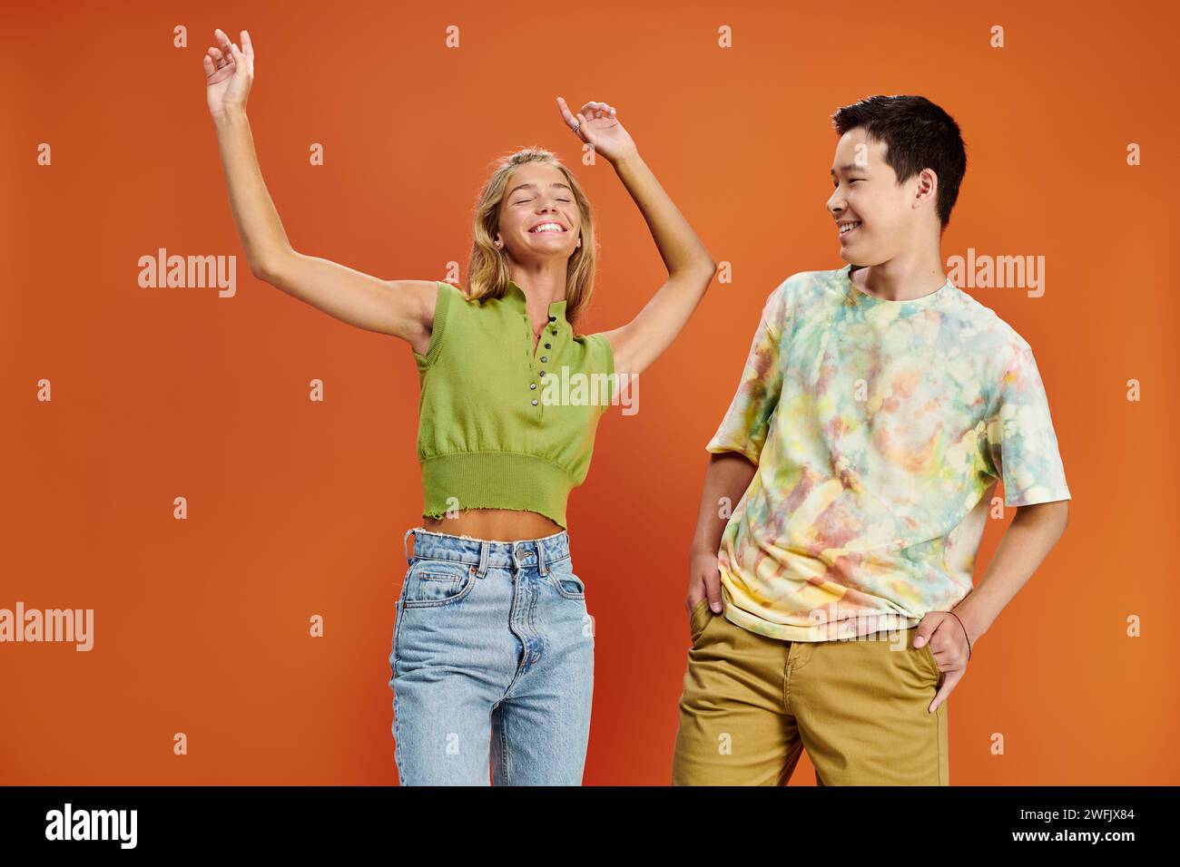 asian teenage boy looking at his cheerful blonde friend in casual