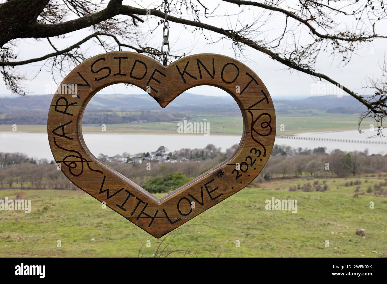 Wooden Heart Carving on Arnside Knott with the Kent Estuary and Viaduct Behind, Arnside, Cumbria, UK Stock Photo