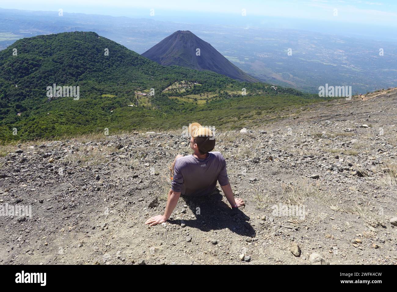 Tourist enjoying views of  Izalco volcano from summit of Santa Ana volcano, El Salvador, Central America Stock Photo