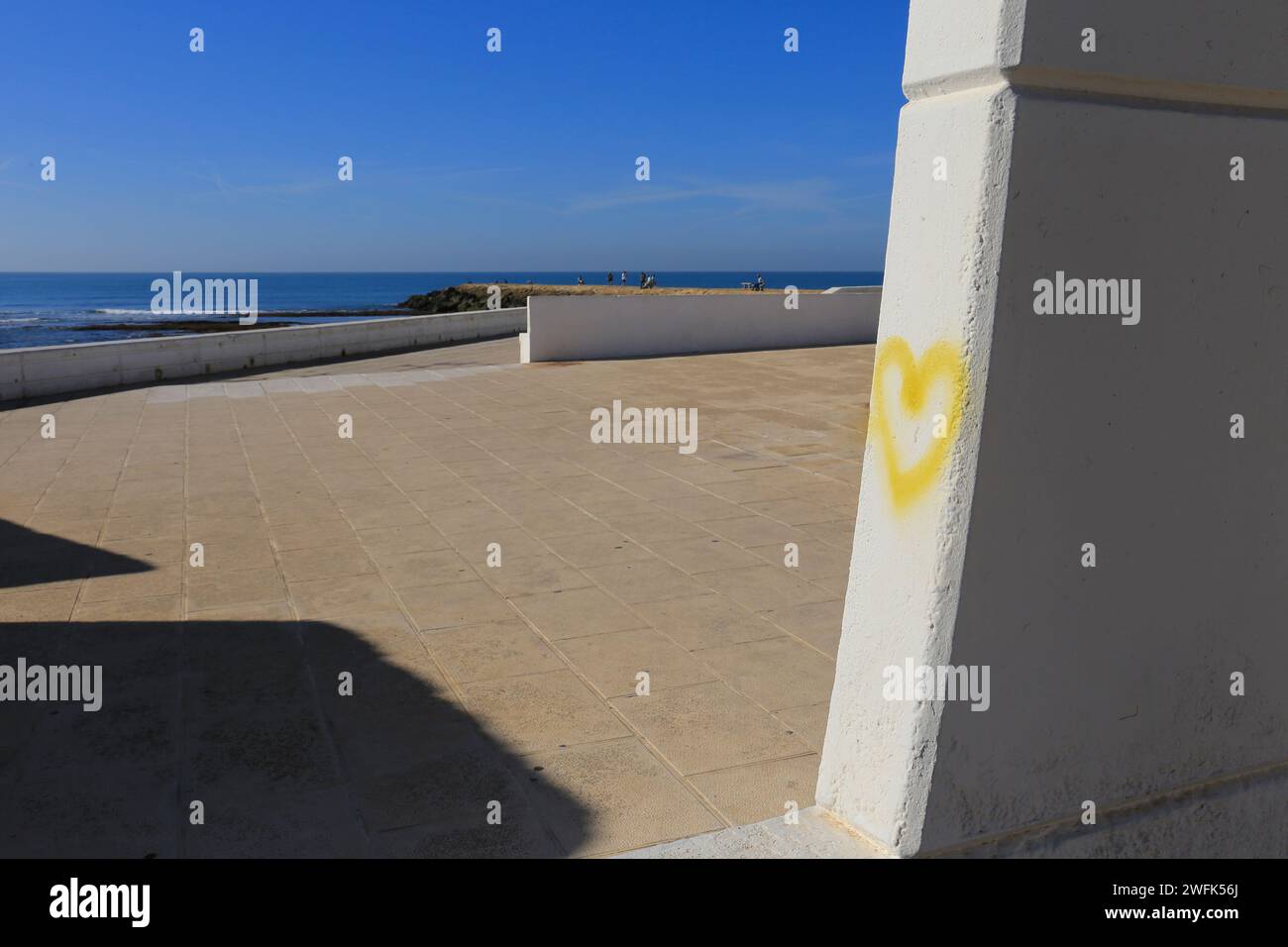Yellow heart drawn on wall on Playa de la Costilla beach and promenade in Rota city, Cadiz, on a sunny day Stock Photo
