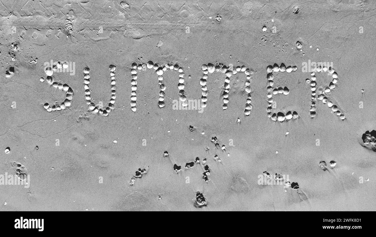 Summer Word on Sand made of Seashells. Top View. Black and white Stock Photo