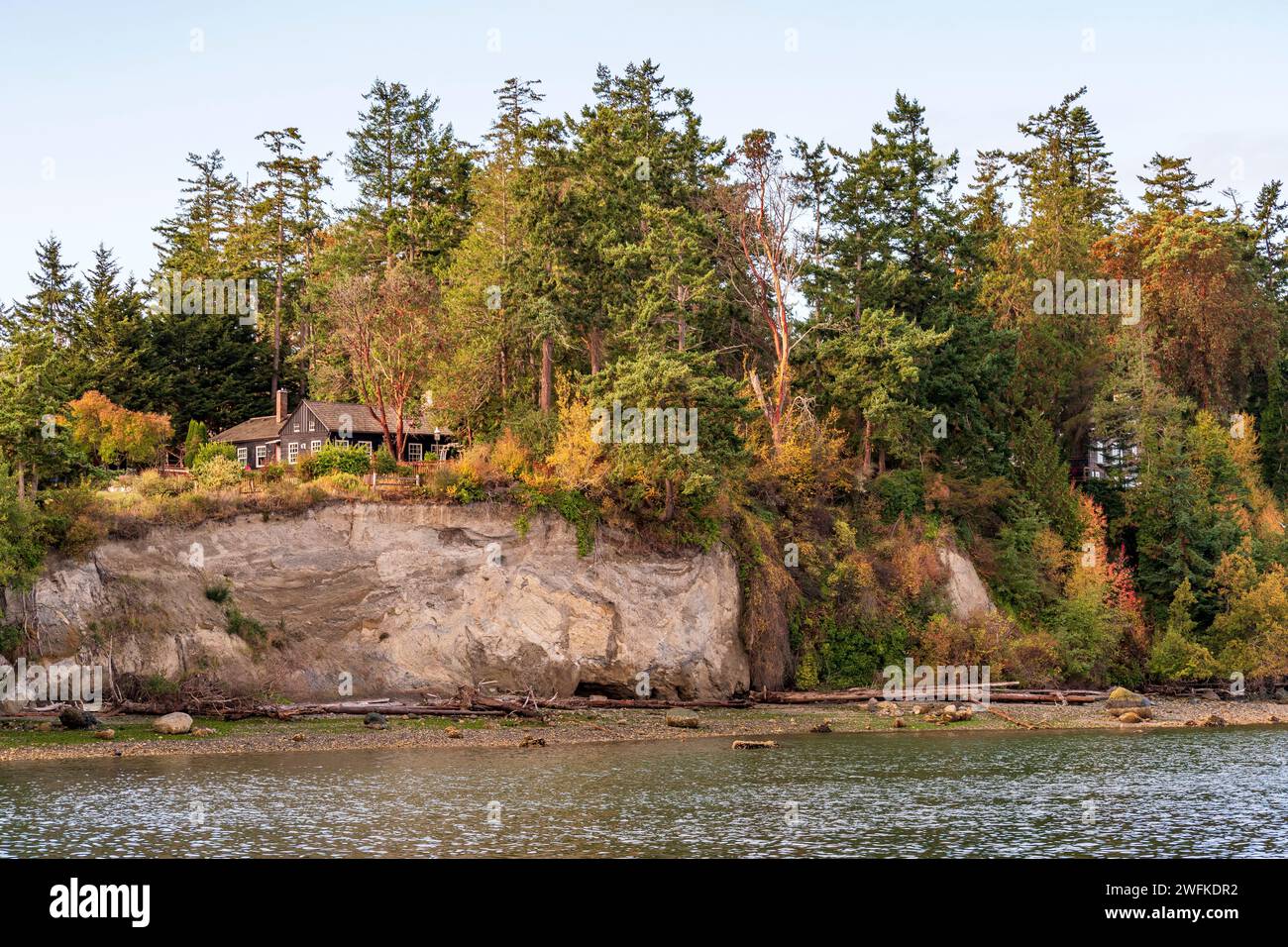 Horizontal photo of a house sitting on a tree-covered bluff above Penn Cove at Coupeville, Whidbey Island, Washington State. Stock Photo