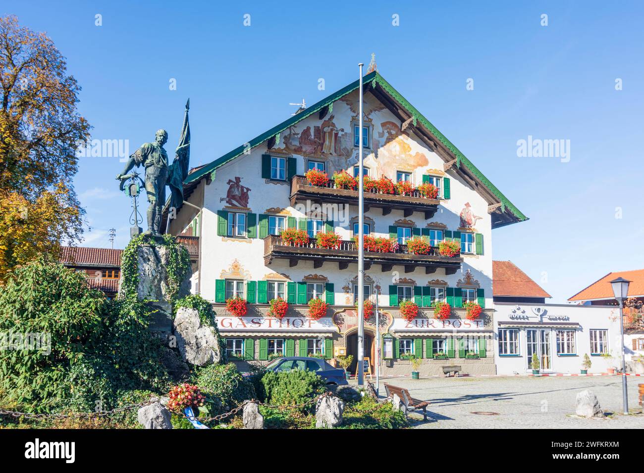 Kochel am See: The Smith of Kochel monument, square Schmied-von-Kochel-Platz, inn Gasthof zur Post in Oberbayern, Tölzer Land, Upper Bavaria, Bayern, Stock Photo