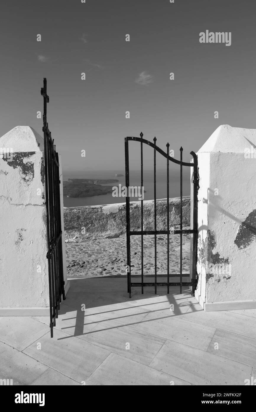 Santorini - The gate of church in Imerovigli with the look to Nea Kameni vulcanic island. Stock Photo