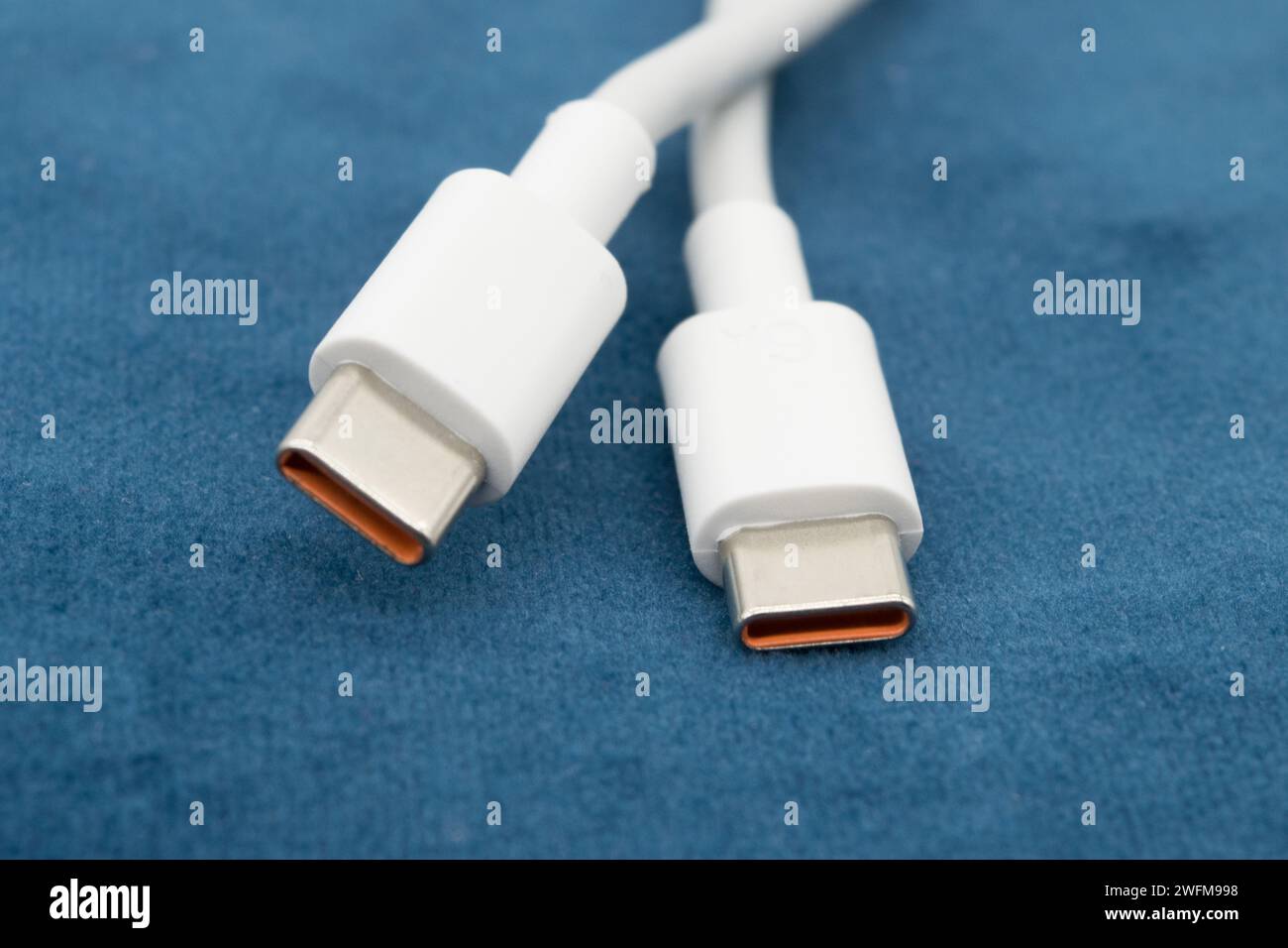 USB-C view of white USB-C plug on dark background. Stock Photo