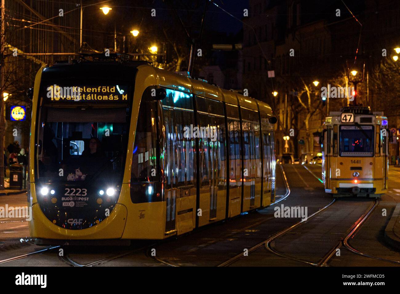 A CAF Urbos 3 tram on line 19 at Moricz Zsigmond Korter in Budapest at night in winter Stock Photo