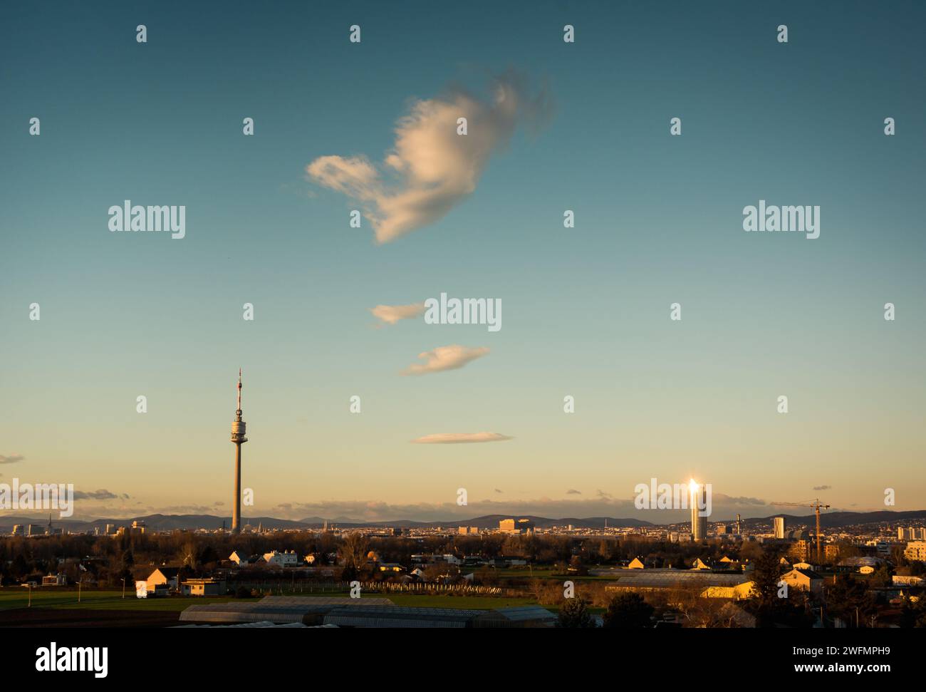 Sunrise view at Danube Tower and Millennium Tower from Kagran. Cityscape of Vienna with low-rise districts and TV tower on the left. Stock Photo