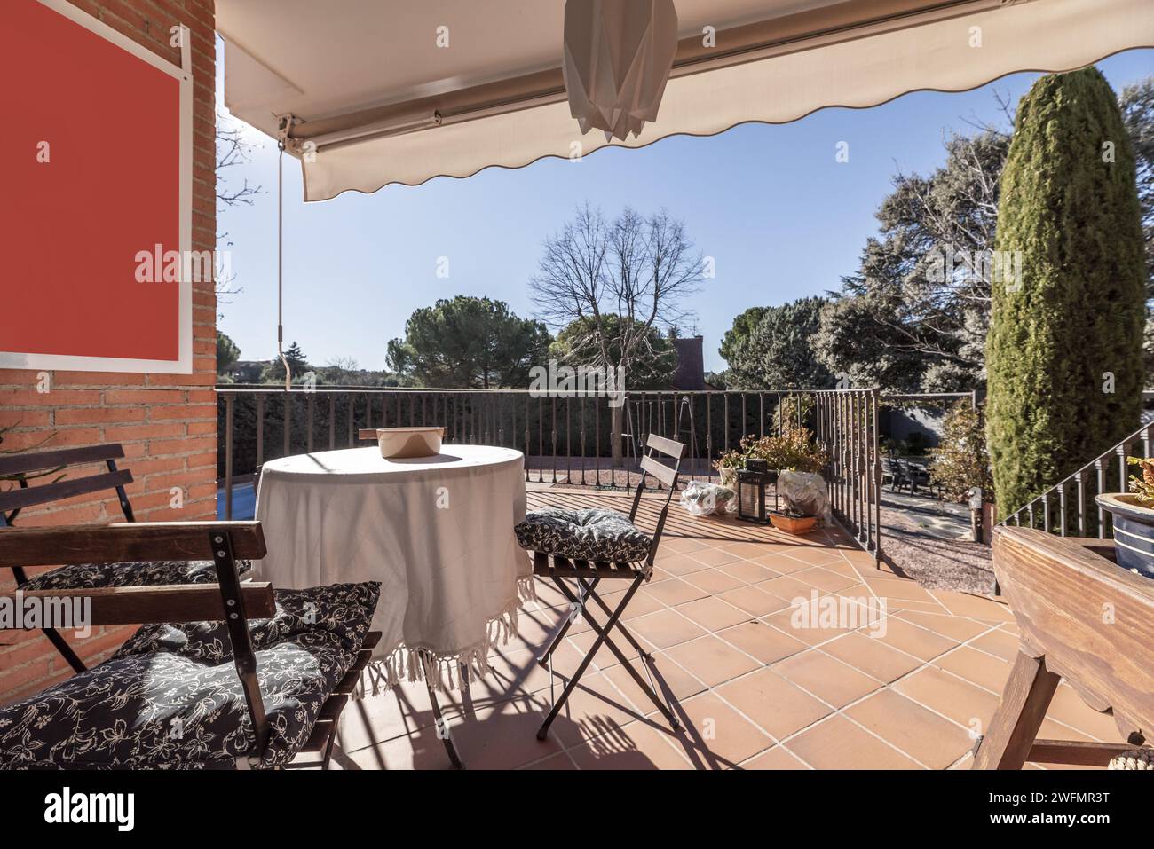 Exterior porch of a single-family home with metal railing, terracotta ...