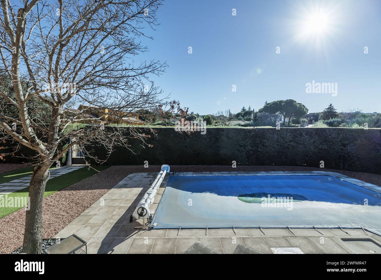 Large plot of single-family home with flagstone walks with a pool covered with a tarp Stock Photo