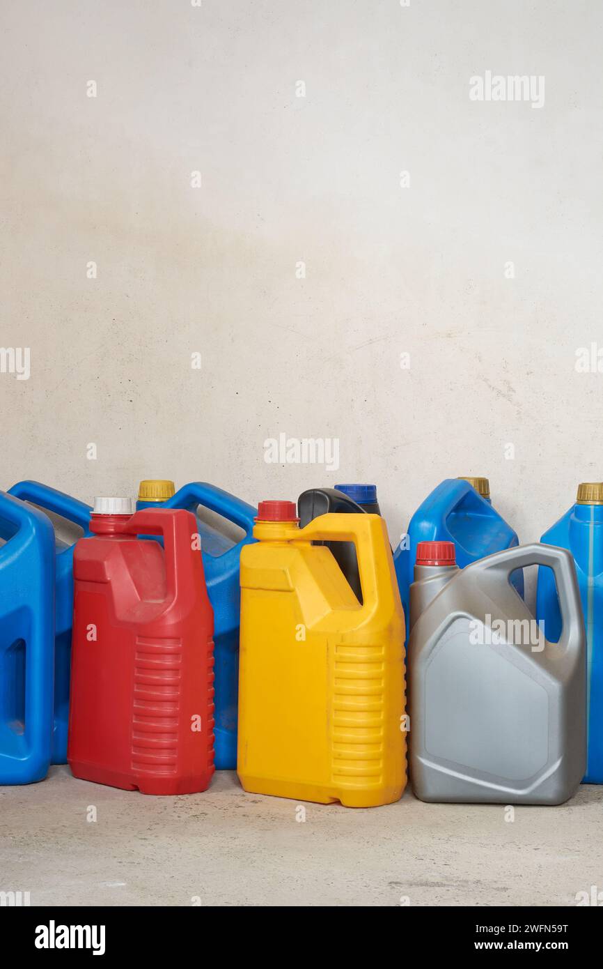 old used plastic oil cans, motor or engine oil chemical gallon for recycle, various sizes and colors of empty waste containers or canisters on white Stock Photo