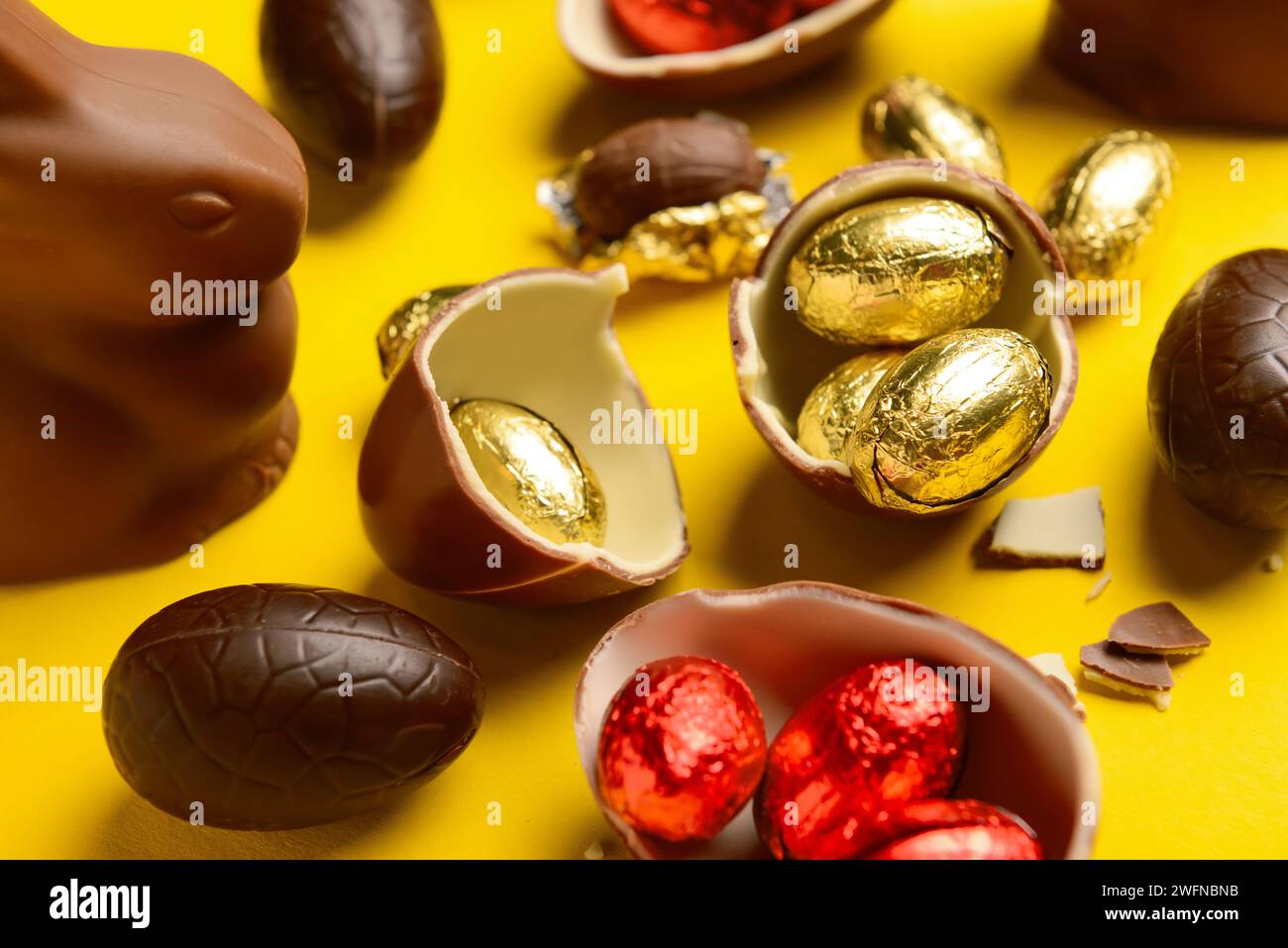 Chocolate Easter eggs and bunny on yellow background Stock Photo