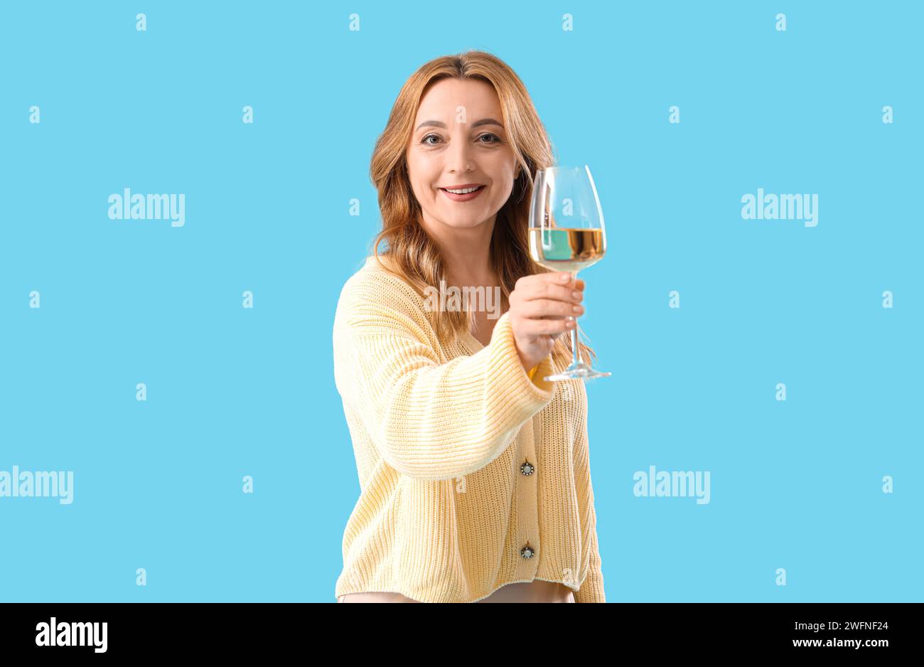 Beautiful mature woman with glass of wine on blue background Stock ...