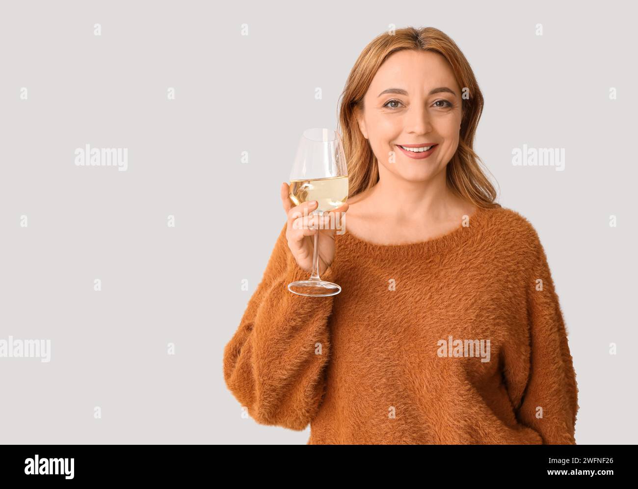 Beautiful mature woman with glass of wine on white background Stock ...