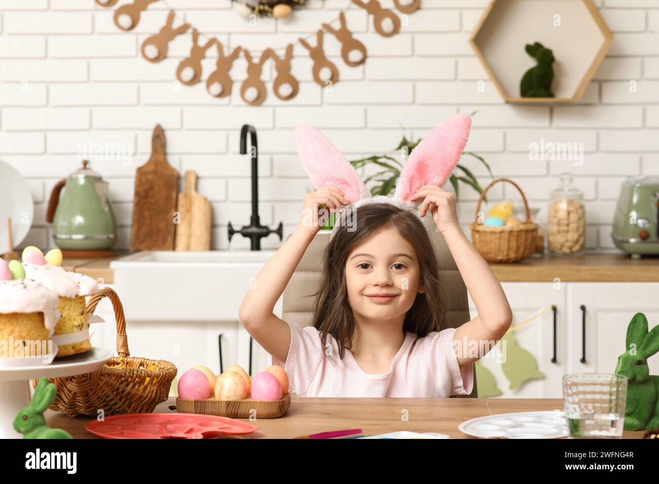 Cute little girl wearing bunny ears with Easter eggs at home Stock ...