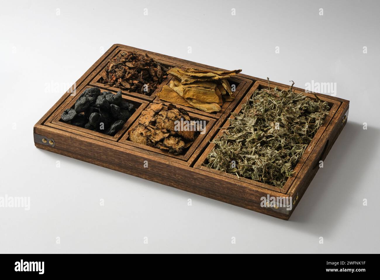 A wooden tray with compartments containing some types of herb. These herbs have great medicinal value and very precious as traditional medicine Stock Photo