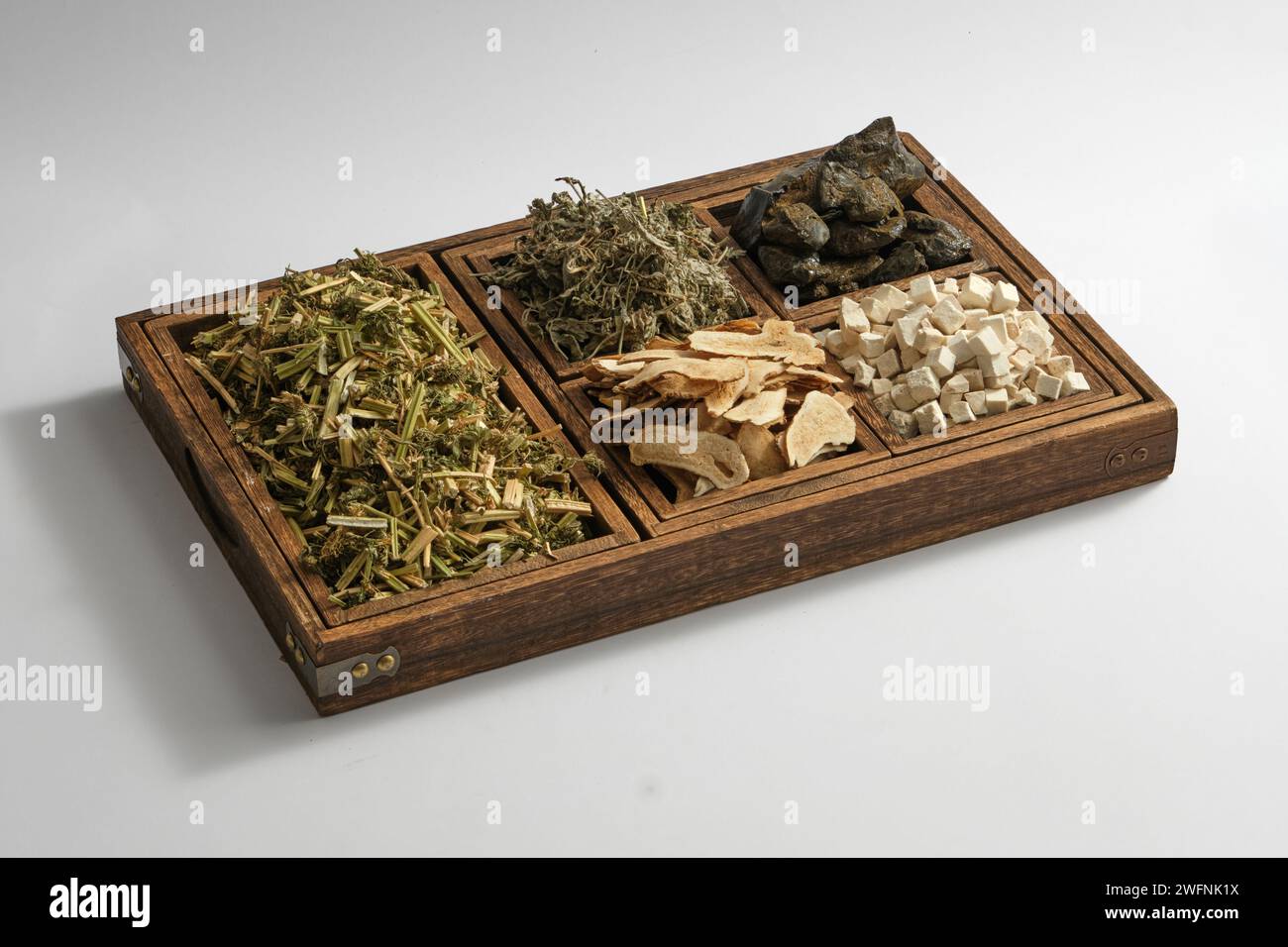 Some types of herb are placed on a wooden tray with five compartments. Herbs are a natural approach to prevention, healing and health support Stock Photo