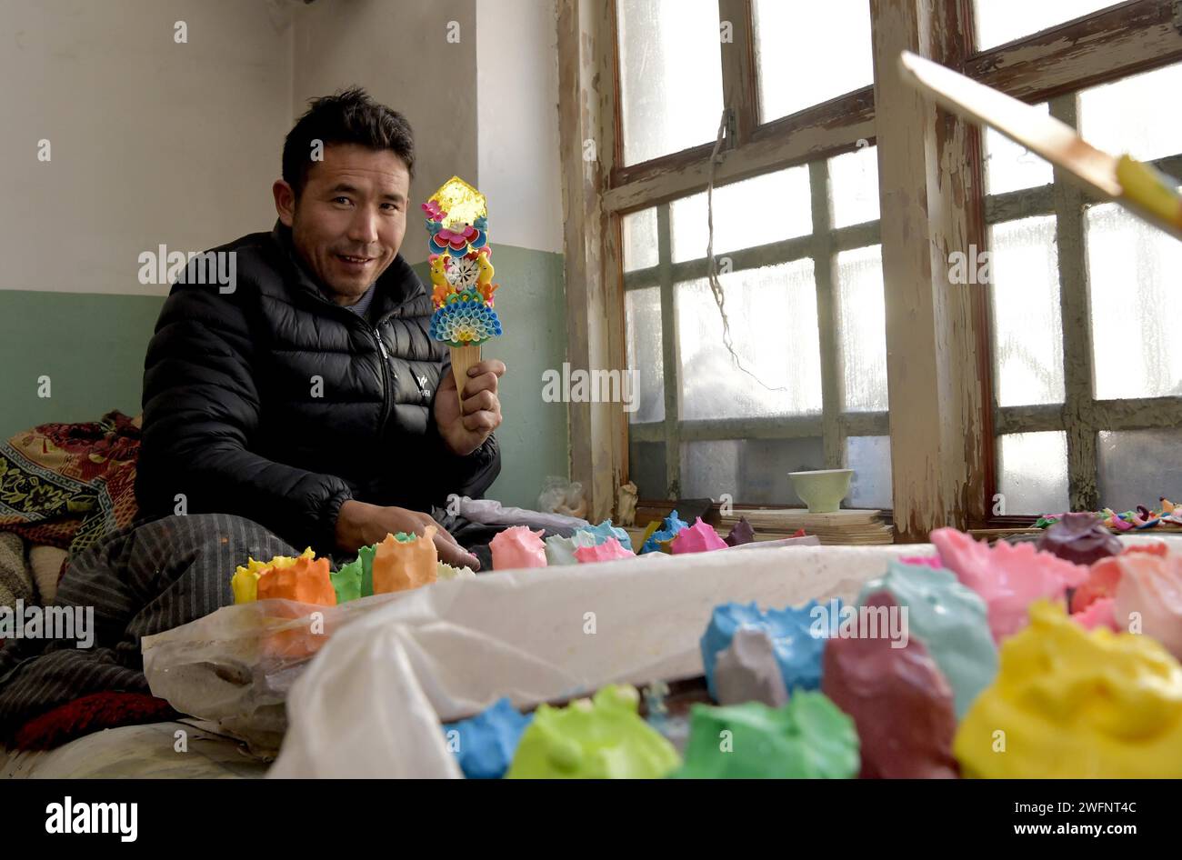 **CHINESE MAINLAND, HONG KONG, MACAU AND TAIWAN OUT** A craftsman displays butter sculptures to greet the upcoming Losar, or Tibetan New Year in Lhasa Stock Photo