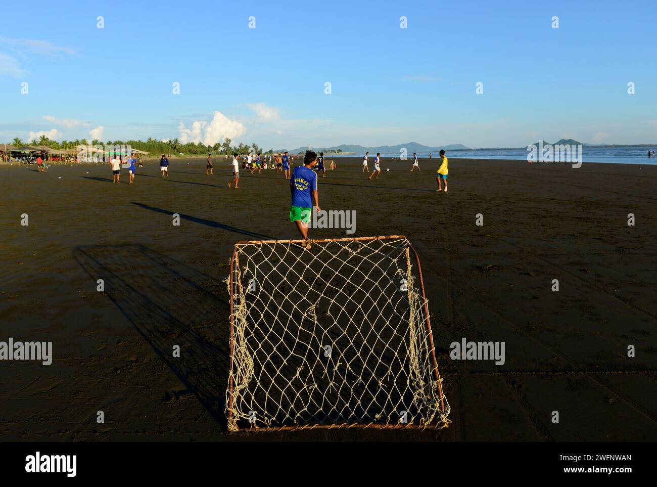 Arakanese men playing football on beach in Sittwe, Rakhine State, Myanmar. Stock Photo