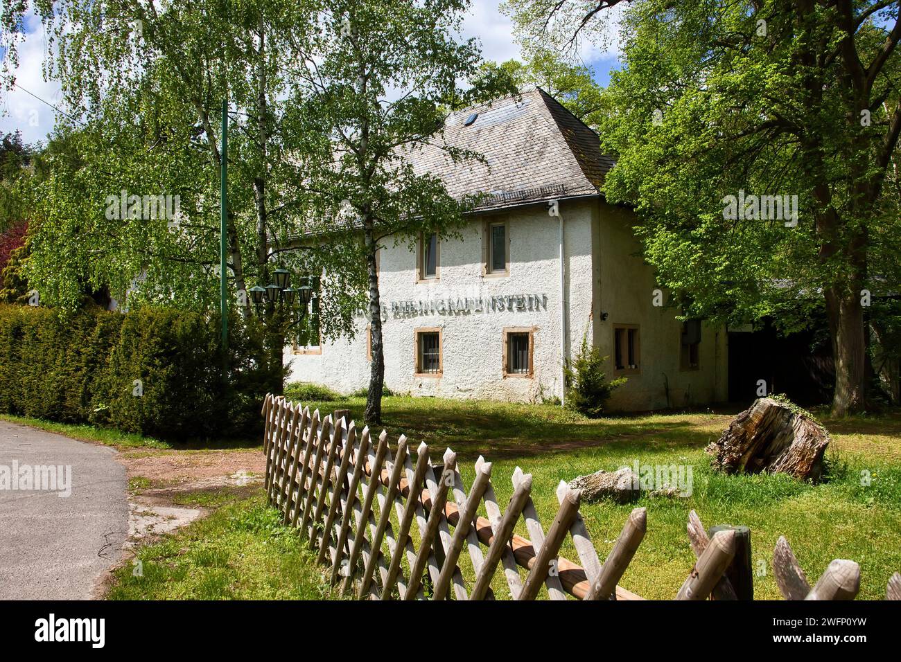 Bad Munster, Germany - May 12, 2021: White building with Rheingrafenstein on the side on a spring day with green grass and trees. Stock Photo
