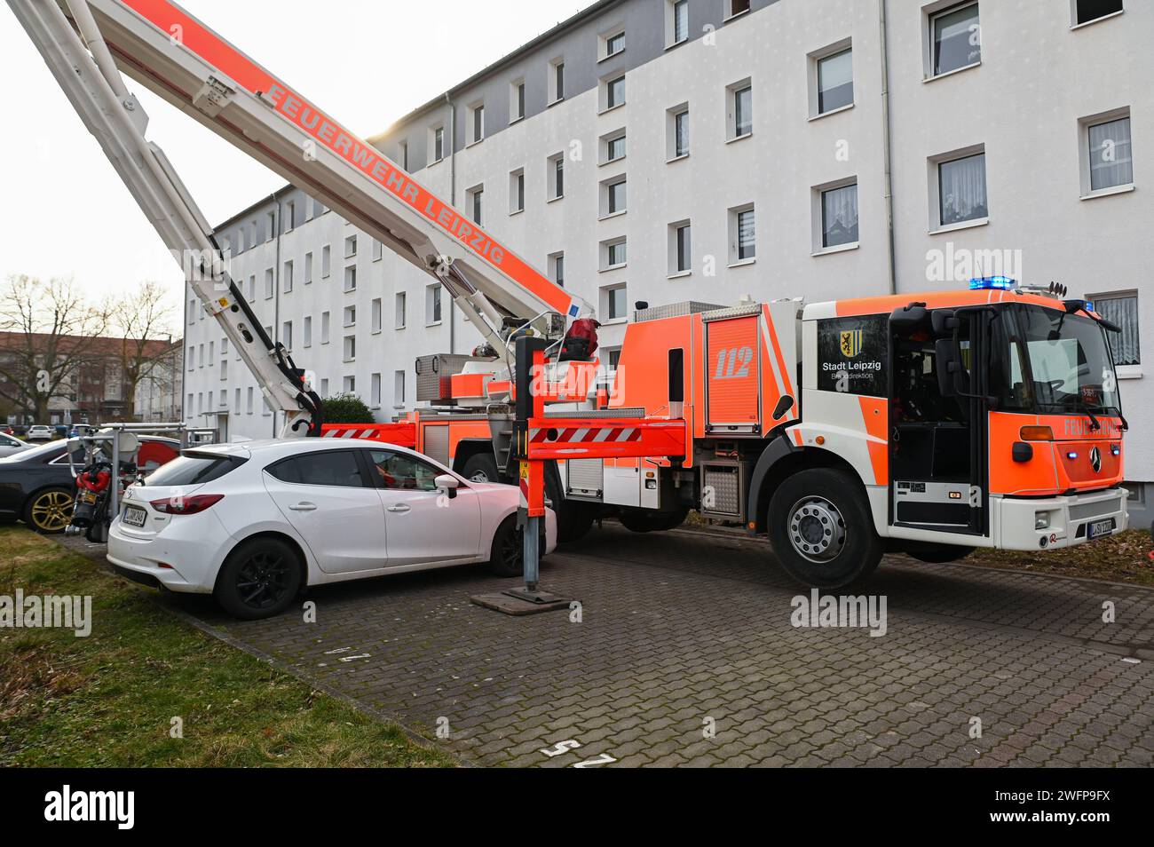 Leipzig - Küchenbrand in Wohnblock: Anwohner evakuiert, Mieterin verletzt 30.01.2024 gegen 12:15 Uhr Leipzig, Nikolai-Rumjanzew-Straße Am Dienstagmittag kam es in einer Wohnung in einem Neubaublock an der Nikolai-Rumjanzew-Straße im Leipziger Südwesten zu einem Brand in einer Küche. Nach ersten Angaben der Feuerwehr brach der Brand gegen 12.15 Uhr in dem Haus aus. Am Brandort angekommen schlugen bereits dunkle Rauchwolken aus dem angekippten Fenster des Wohnblocks. Unter Atemschutz gingen die Feuerwehrleute in die Wohnung, holten eine verletzte Frau raus und übergaben sie an den Rettungsdienst Stock Photo