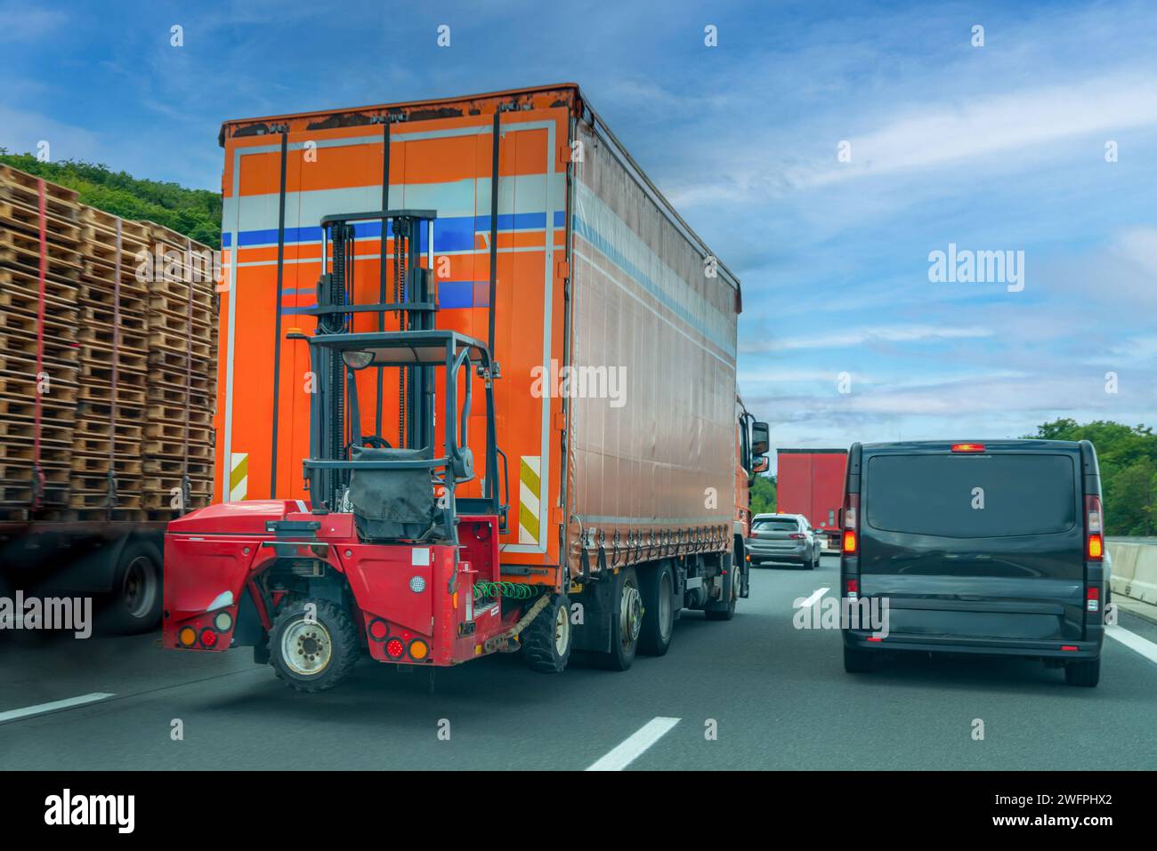 Truck-mounted forklifts, also known as piggyback forklifts driving on heavy traffic on motorway Stock Photo