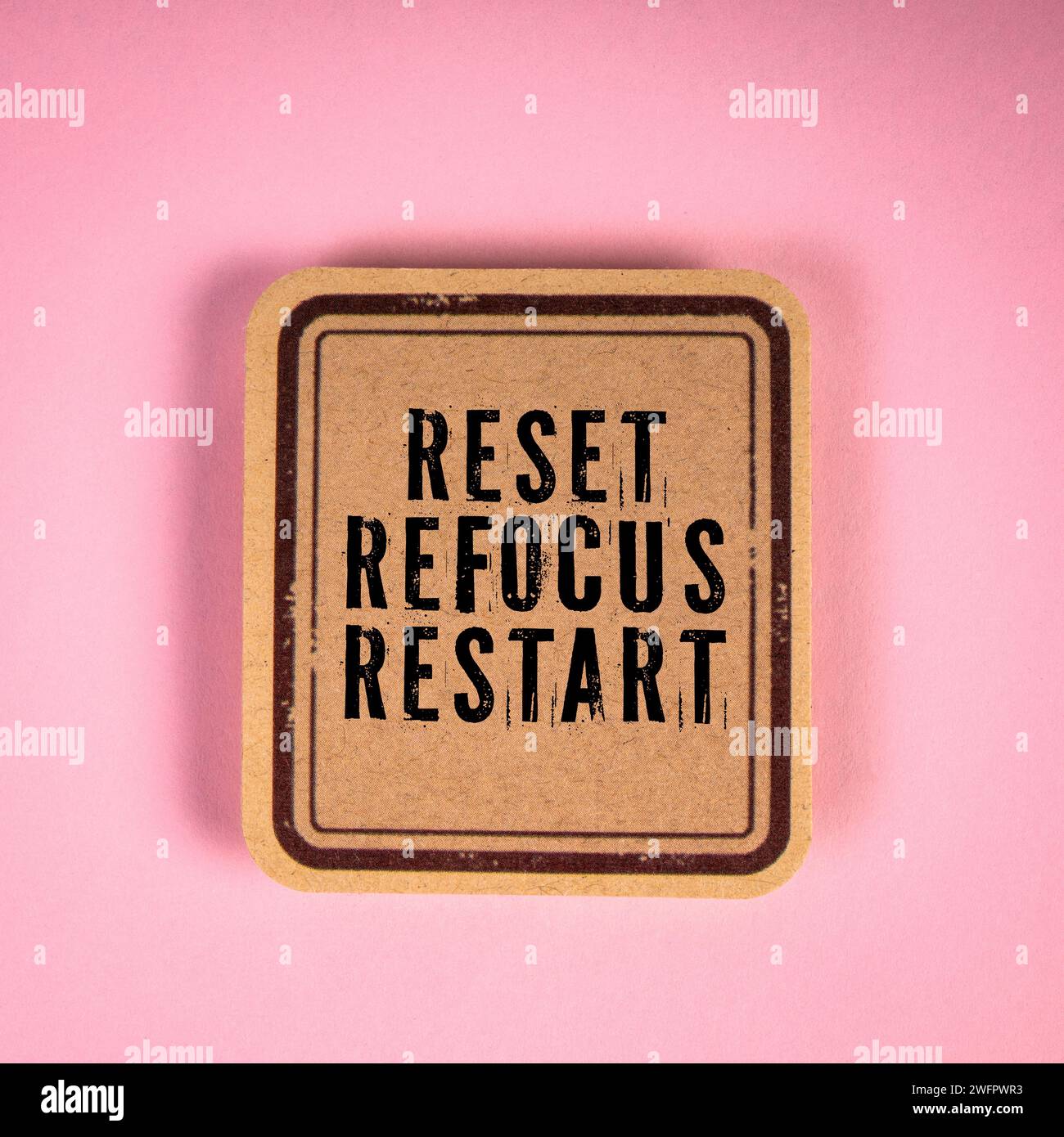 RESET REFOCUS RESTART. Cardboard sticker with text on a pink background ...