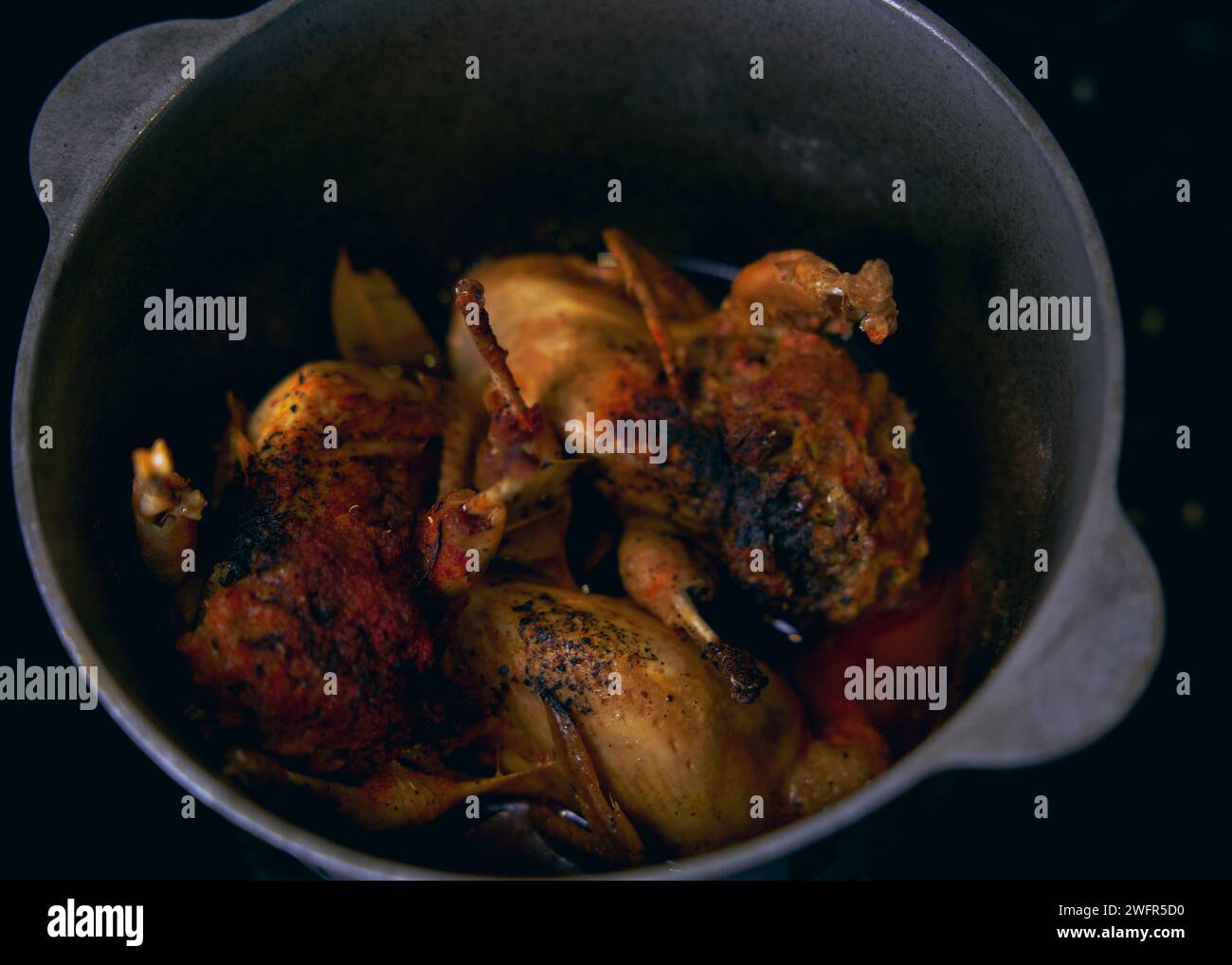 Quails stuffed with giblets and cooked in a cast iron cauldron Stock Photo
