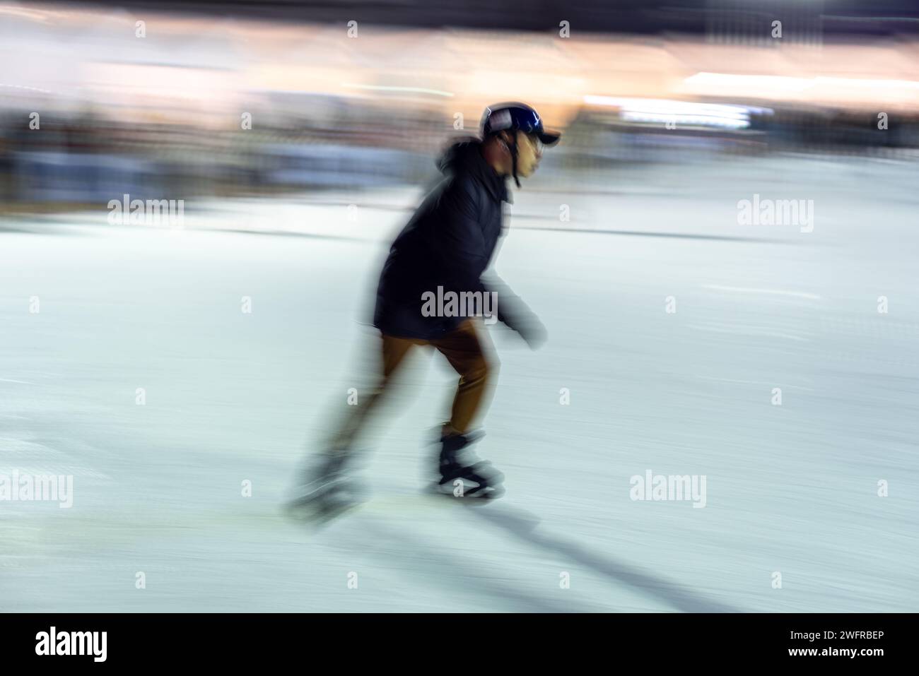 Intentional blur of people ice skating at night on the temporary ice skating ring in front of the City Hall in Seoul South Korea on 29 January 2024 Stock Photo