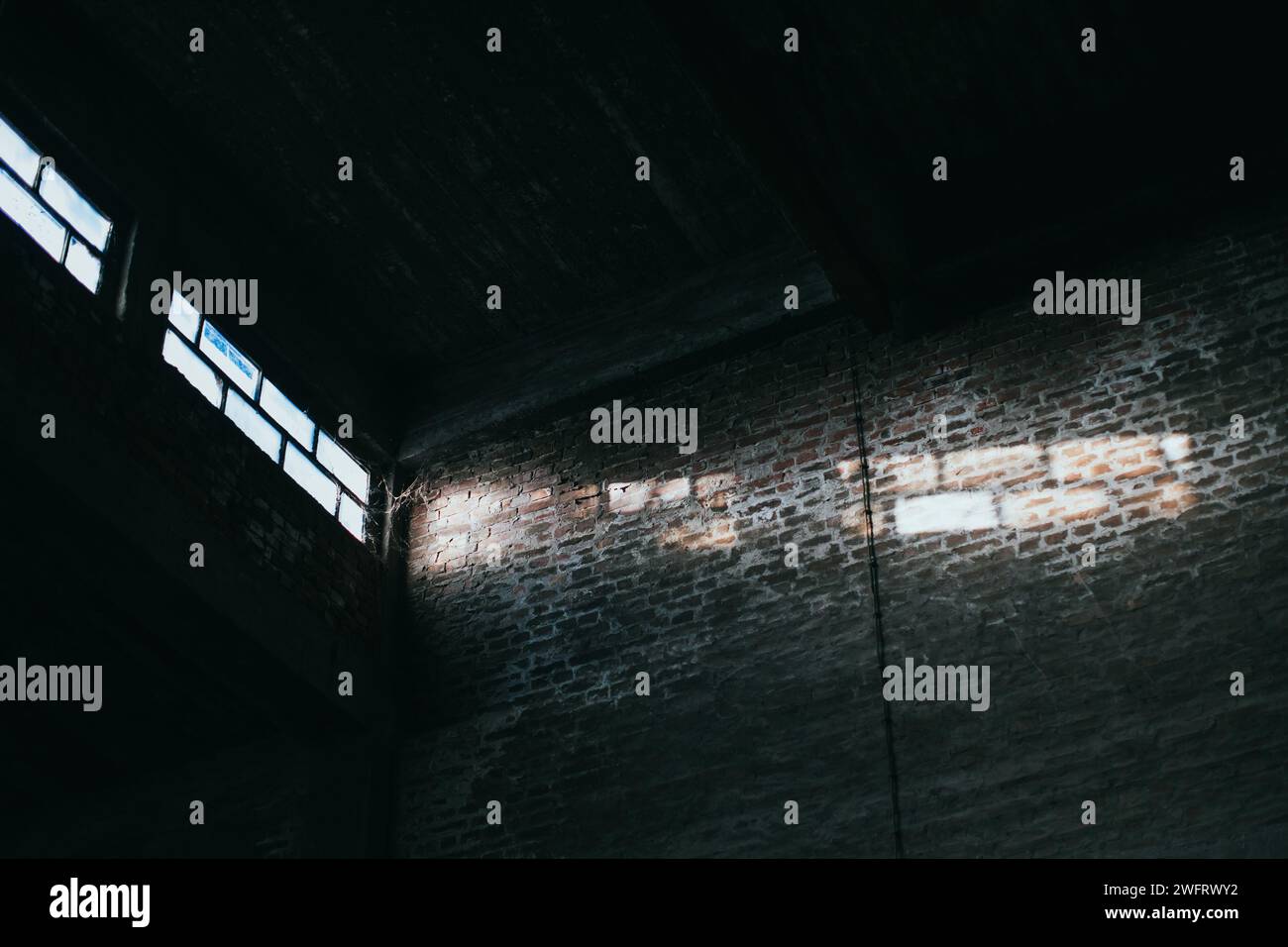 sunlight rays from large windows in dark warehouse Stock Photo