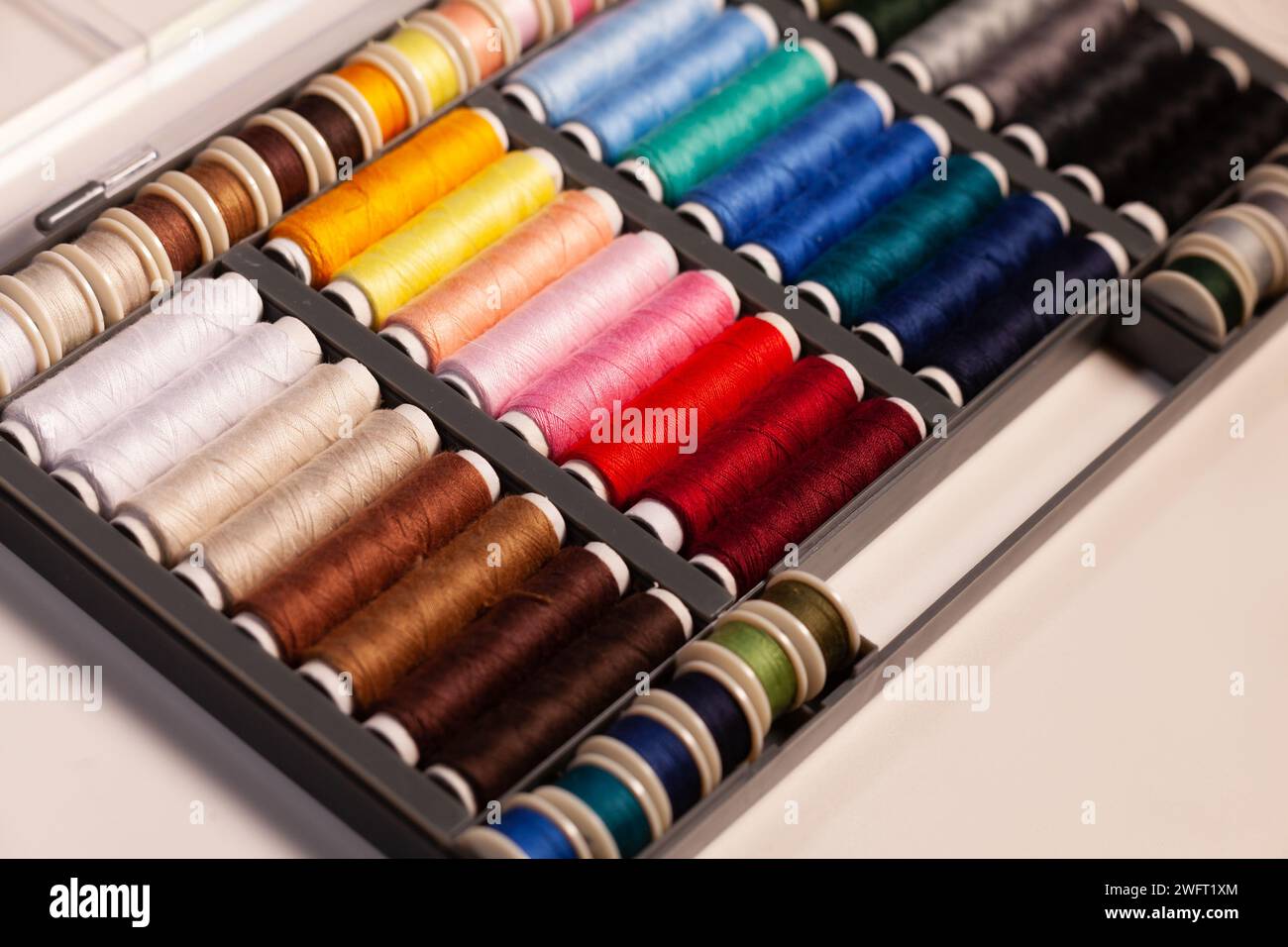 many colorful sewing threads on spools Stock Photo