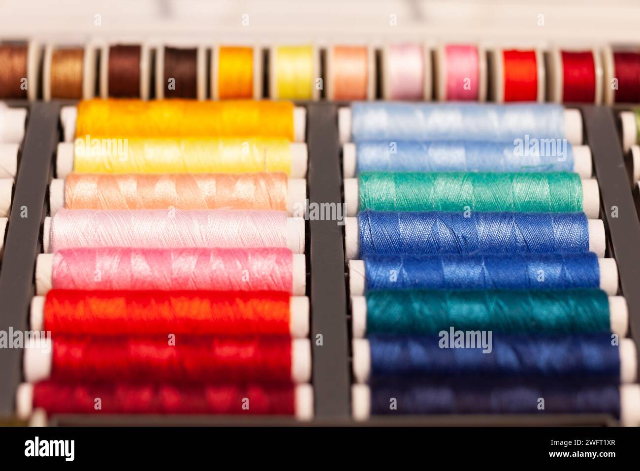 many colorful sewing threads on spools Stock Photo