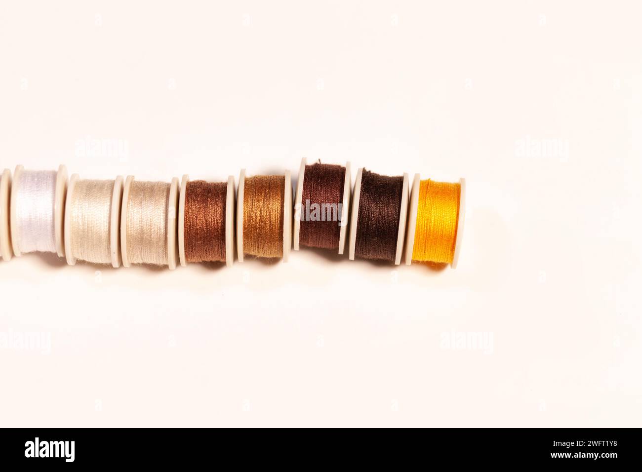 colorful sewing threads on bobbins isolated on white Stock Photo