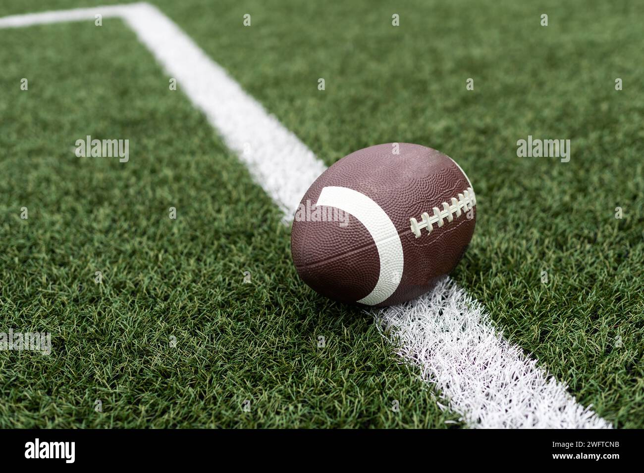Football on hash marks of high school turf football field Stock Photo