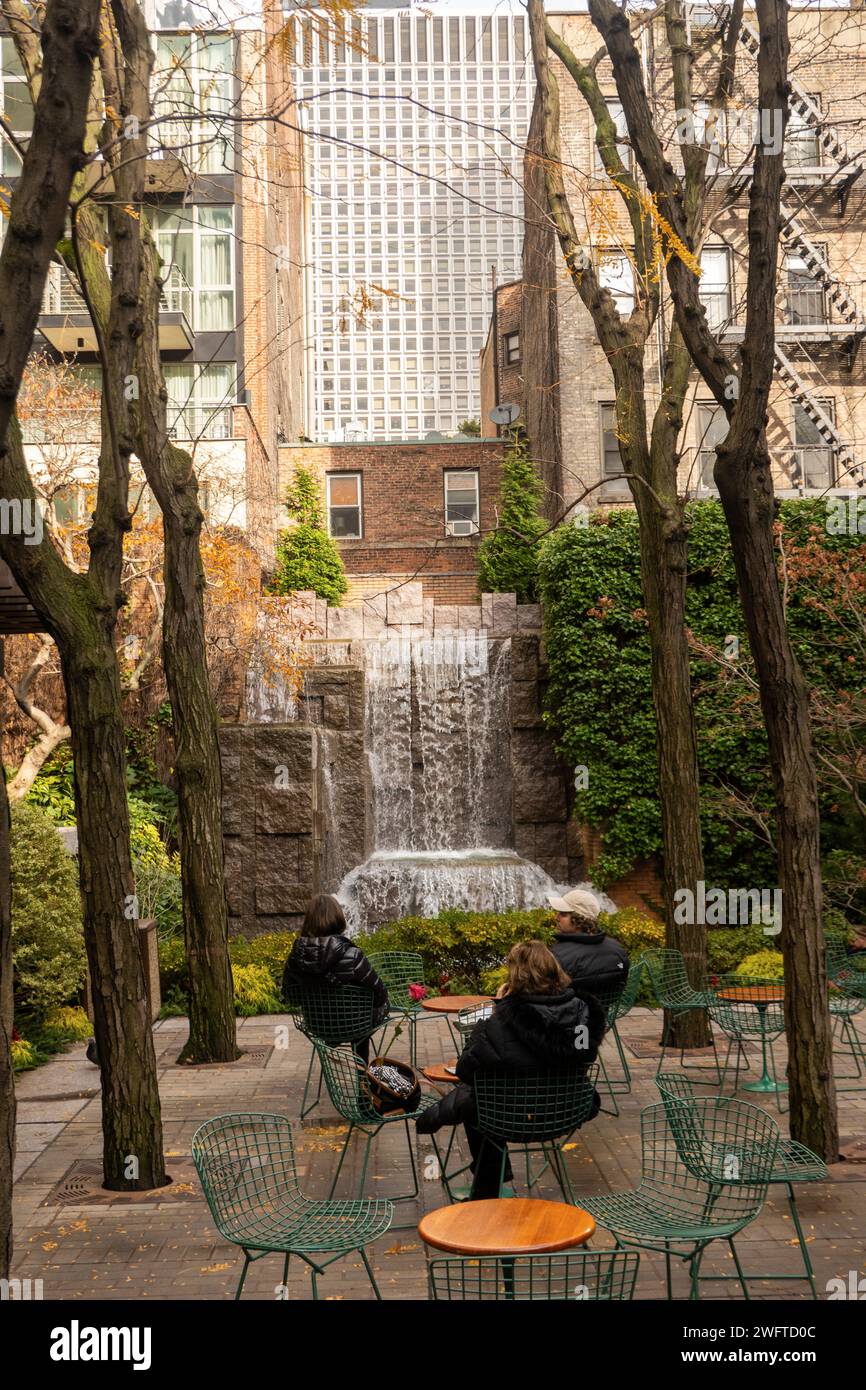 people relaxing in Greenacre park in the Turtle Bay neighborhood of Manhattan NYC Stock Photo