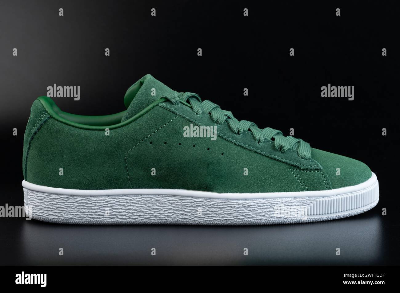 One green casual shoe with laces side view on black studio background Stock Photo