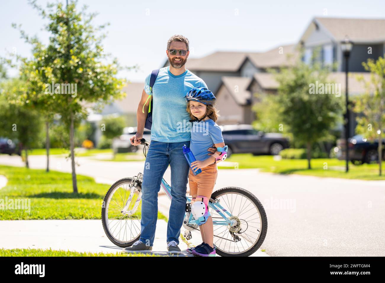 father and son enjoying a bicycle ride. outdoor activities. active son and father duo cycling through scenic countryside on bicycle. father teaching h Stock Photo