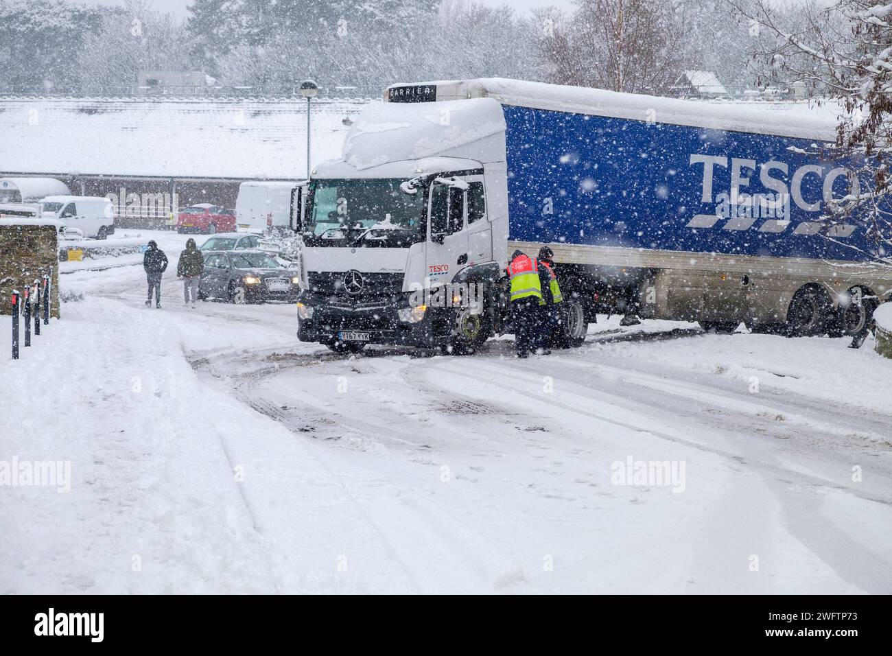 Tesco staff in Chippenham are pictured as they try to free a Tesco delivery truck that has become stuck due to the snow and ice outside the store. Stock Photo