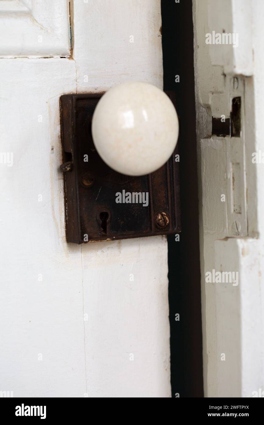 Antique door knob and lock on an ajar door. Stock Photo