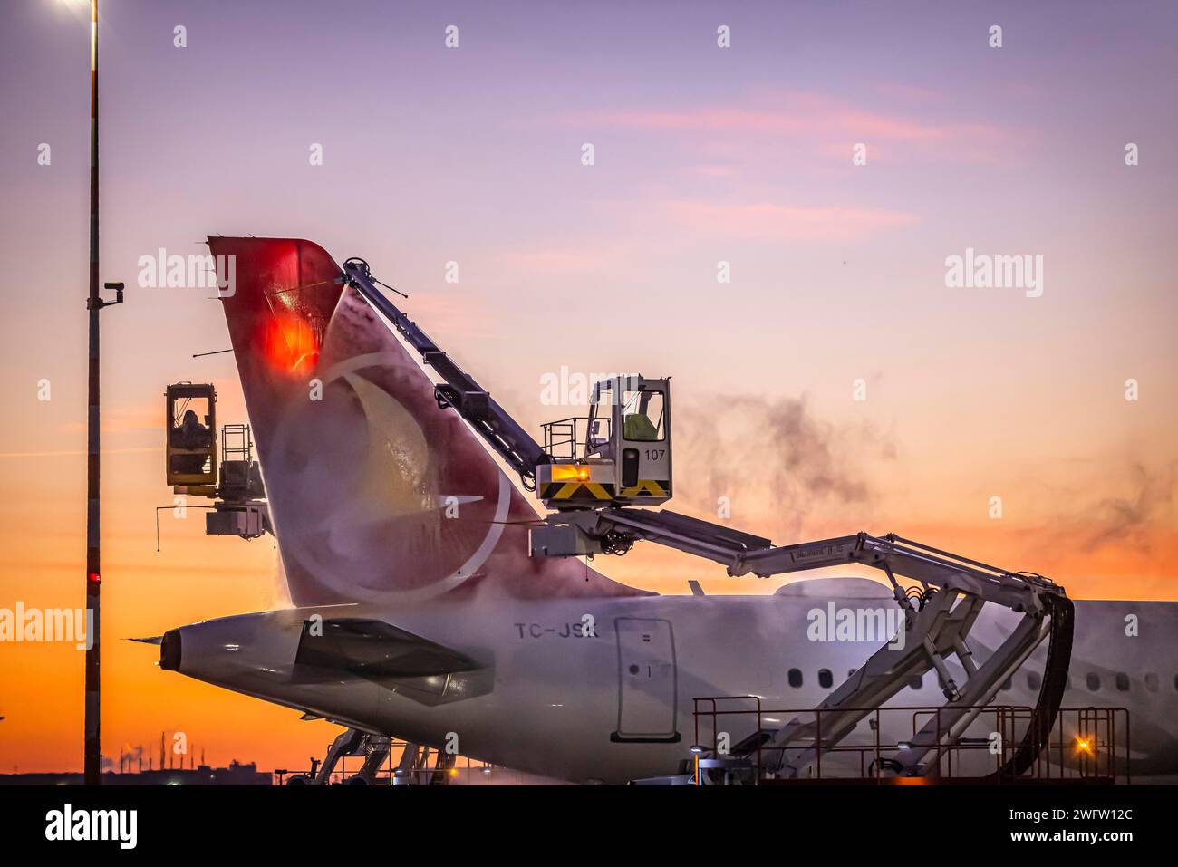 Frost at the airport, a Turkish Airlines aircraft is de-iced in front of sunrise. Airbus A321-231, Fraport, Frankfurt am Main, Hesse, Germany Stock Photo