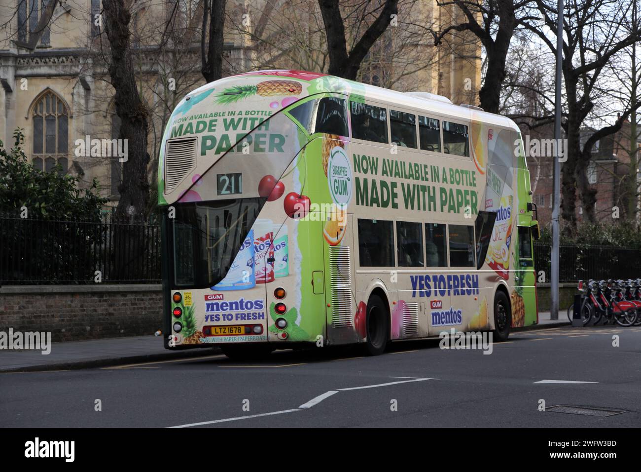 Double Decker Bus with Advertisment for Mentos at Bus Stop on Sydney Street Chelsea London England Stock Photo