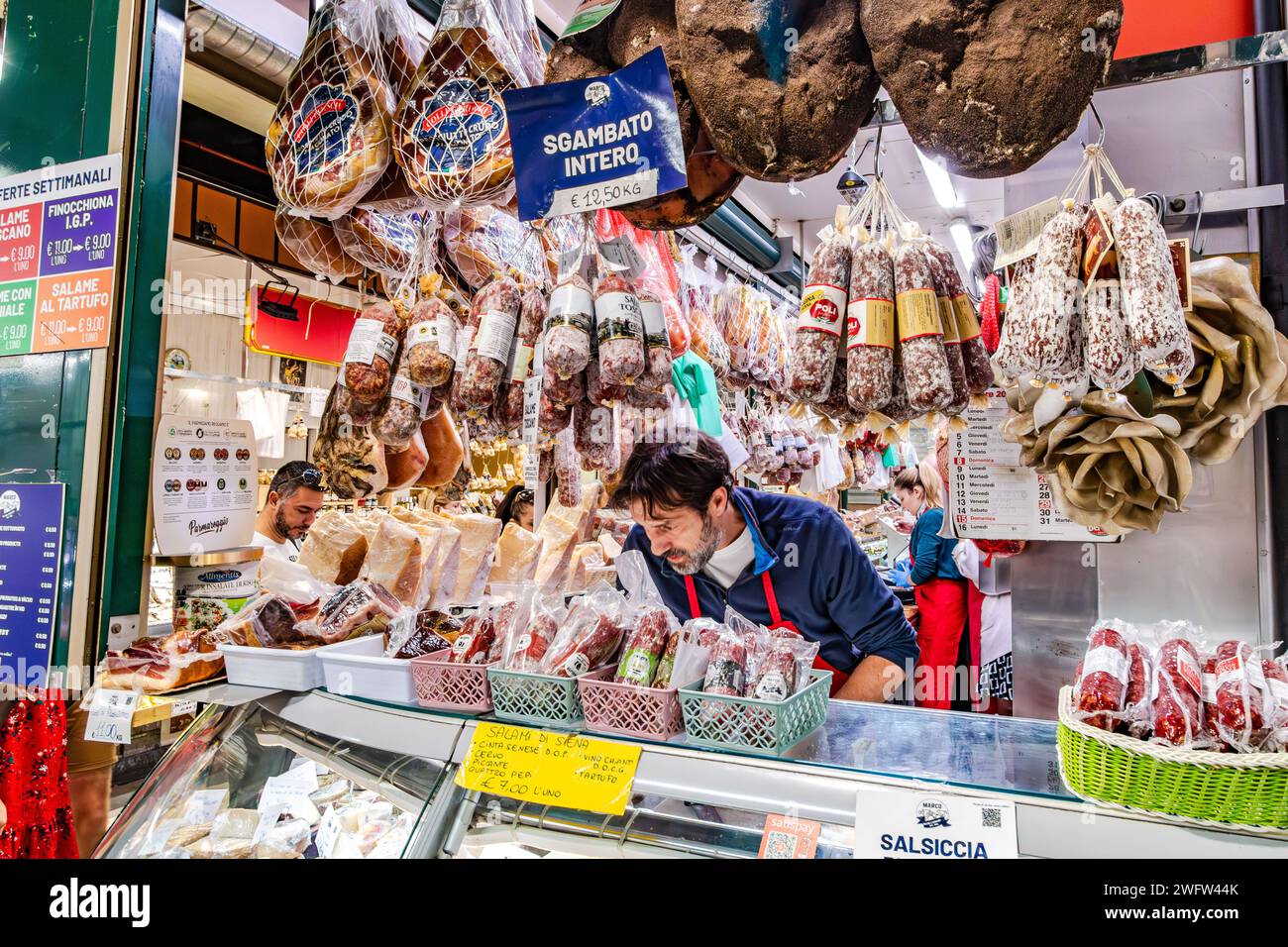 Salami and other cured meats and cheeses on sale at Florence Mercato Centrale, a busy popular fresh food and produce market in Florence, Italy Stock Photo