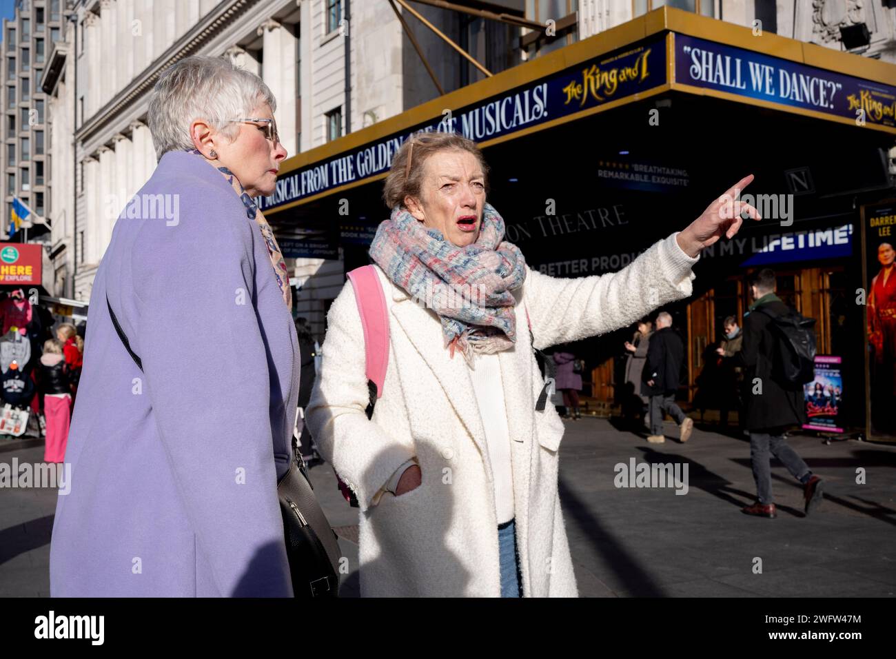Two women decide on directions outside the Dominion Theatre on the Tottenham Court Road, on 1st February 2024, in London, England. Stock Photo