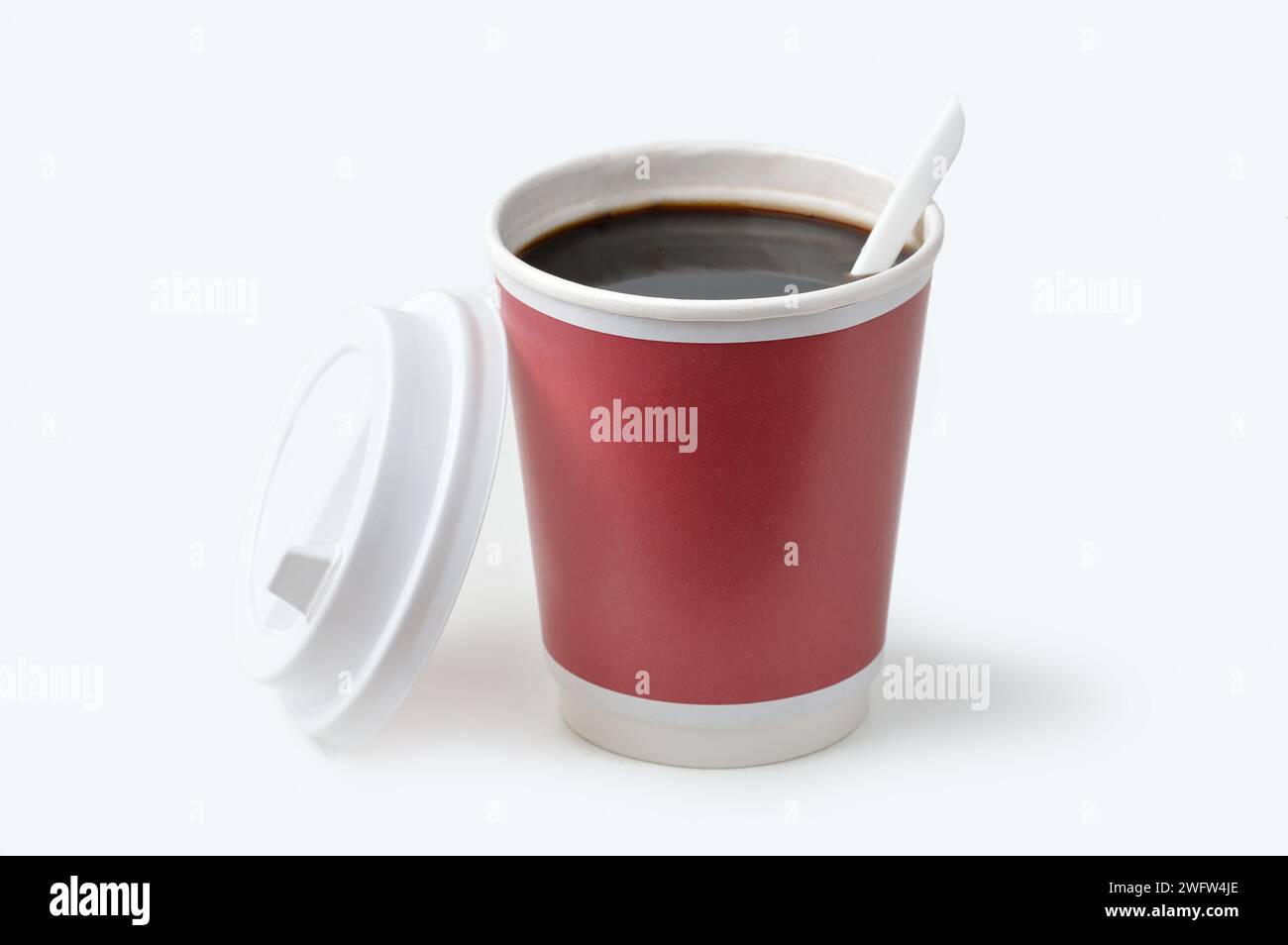 Disposable cup of coffee with a plastic spoon, isolated on white Stock Photo