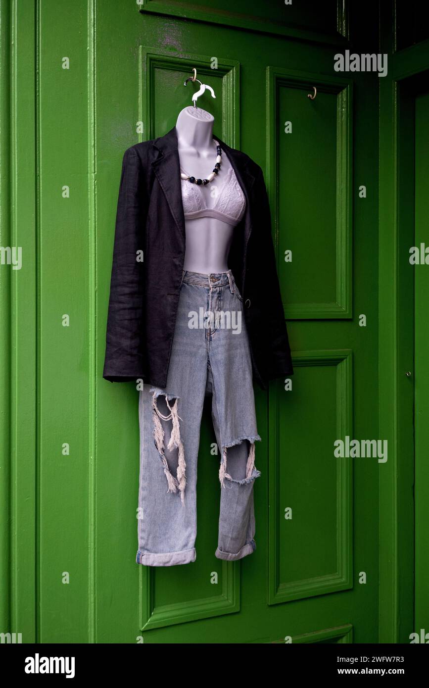 Clothes on a hangar by the door of a charity shop in Newington, Edinburgh, Scotland, UK. Stock Photo