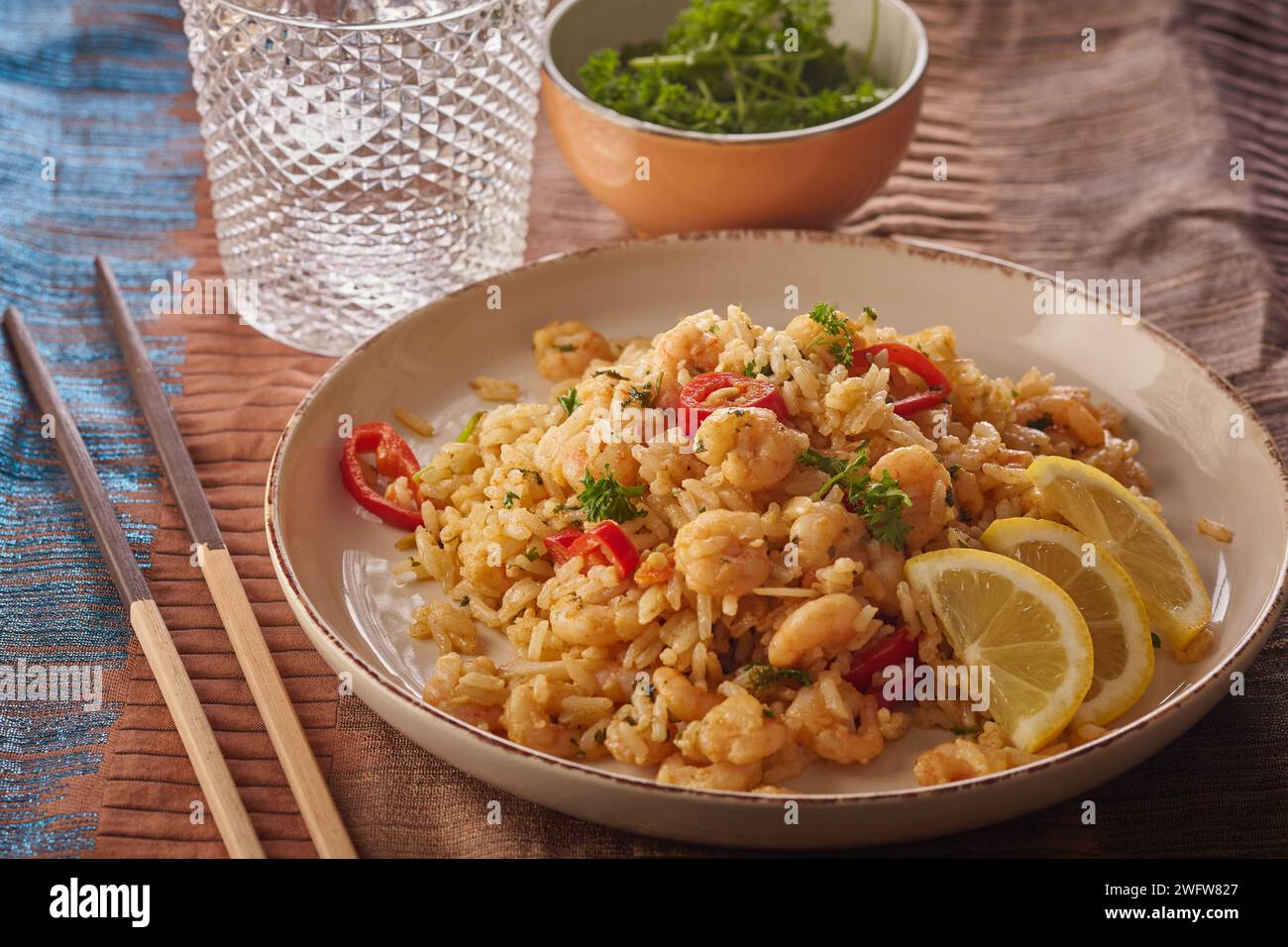 Spicy prawn stir fry with rice garnished with herbs. Stock Photo